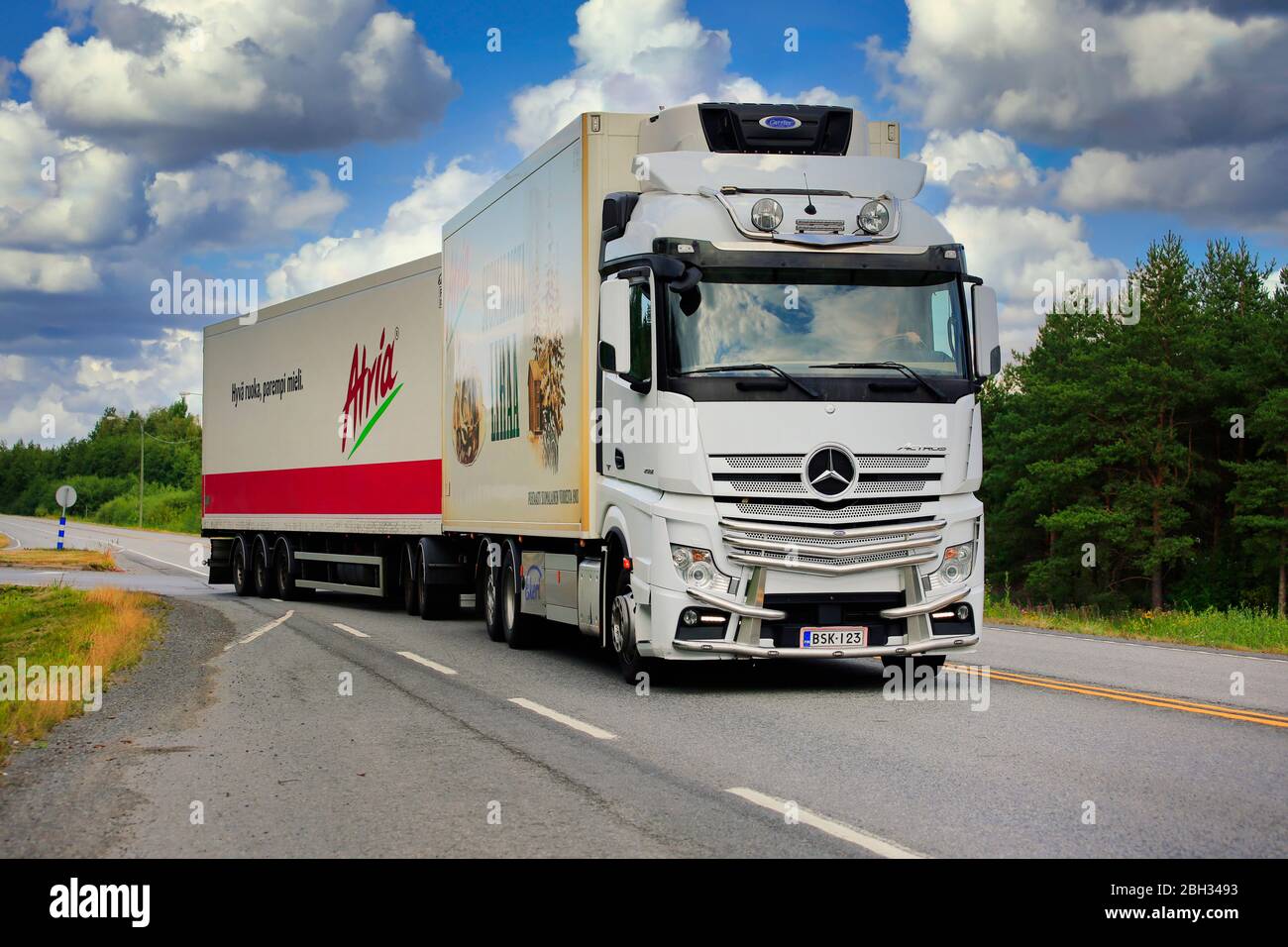 Il bianco Mercedes-Benz Actros Truck tira i prodotti alimentari Atria in un rimorchio refrigerato sulla strada statale 19 in un giorno d'estate. Nurmo, Finlandia. 9 agosto 2019. Foto Stock