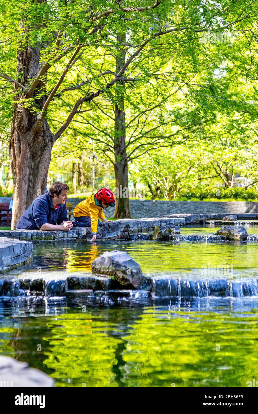 19 aprile 2020 - Londra, Regno Unito, padre e bambino che godono di una giornata di primavera al Jubilee Park, Canary Wharf, durante il blocco pandemico di Coronavirus Foto Stock