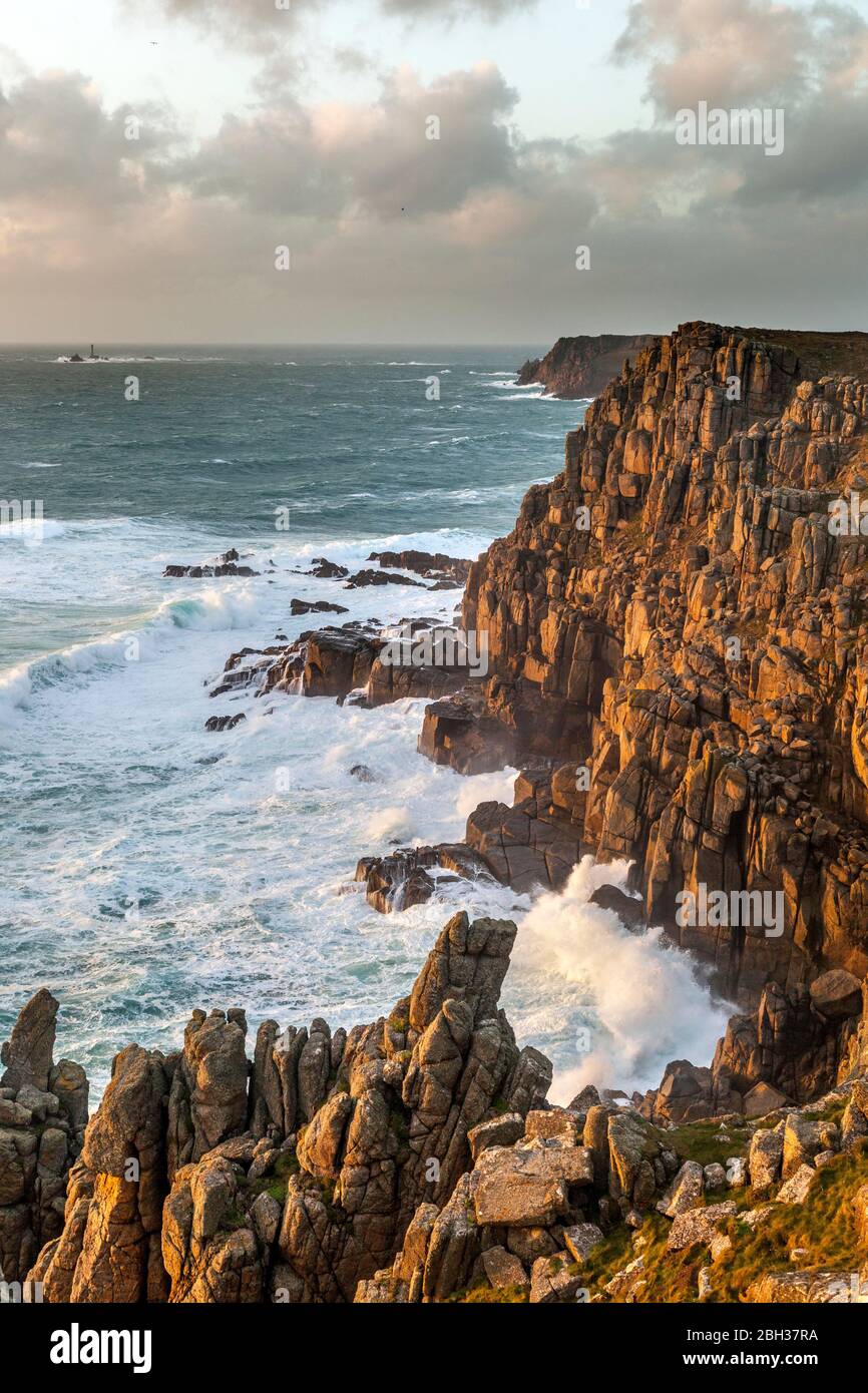 Da vicino alla testa Gwennap guardando verso Longships lighthouse e Land's End; giornata di vento in inverno la fustigazione onde; Cornovaglia Foto Stock