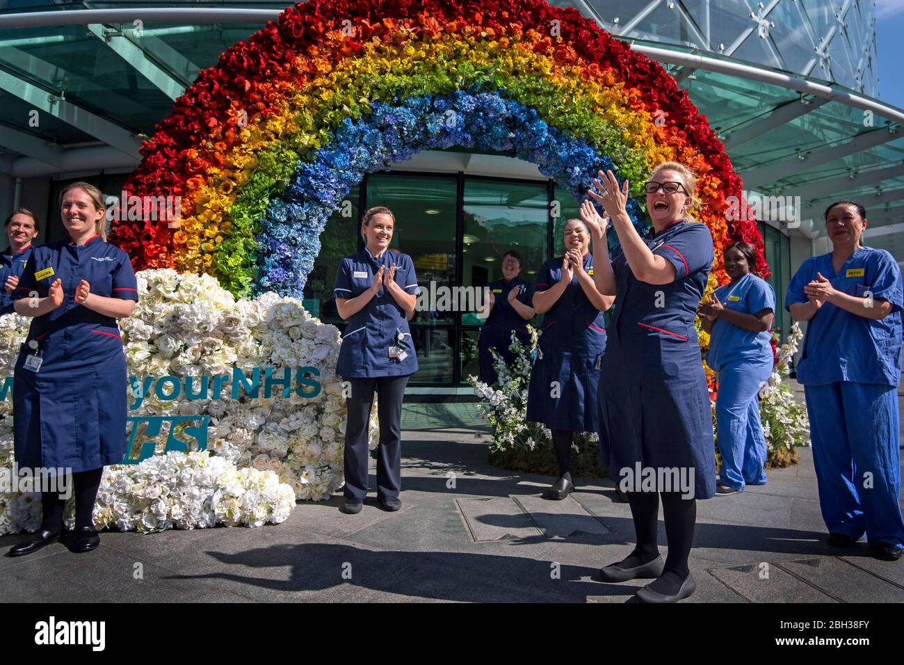 Gli infermieri NHS aiutano a svelare una mostra floreale arcobaleno all'esterno dell'University College Hospital di Euston Road, a Londra, per ringraziare il pubblico per il loro sostegno durante la pandemia di Coronavirus in corso. Foto Stock