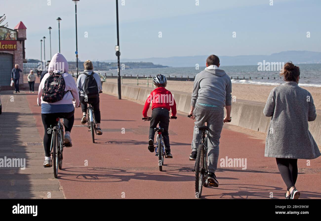 Portobello, Edimburgo, Scozia, Regno Unito. 23 aprile 2020. Pomeriggio soleggiato ma ventilato. Più persone locali si avventurano verso il mare forse incoraggiati dal sole a svolgere il loro esercizio quotidiano permesso, ancora quasi tanti ciclisti come i pedoni sulla Promenade. Foto Stock