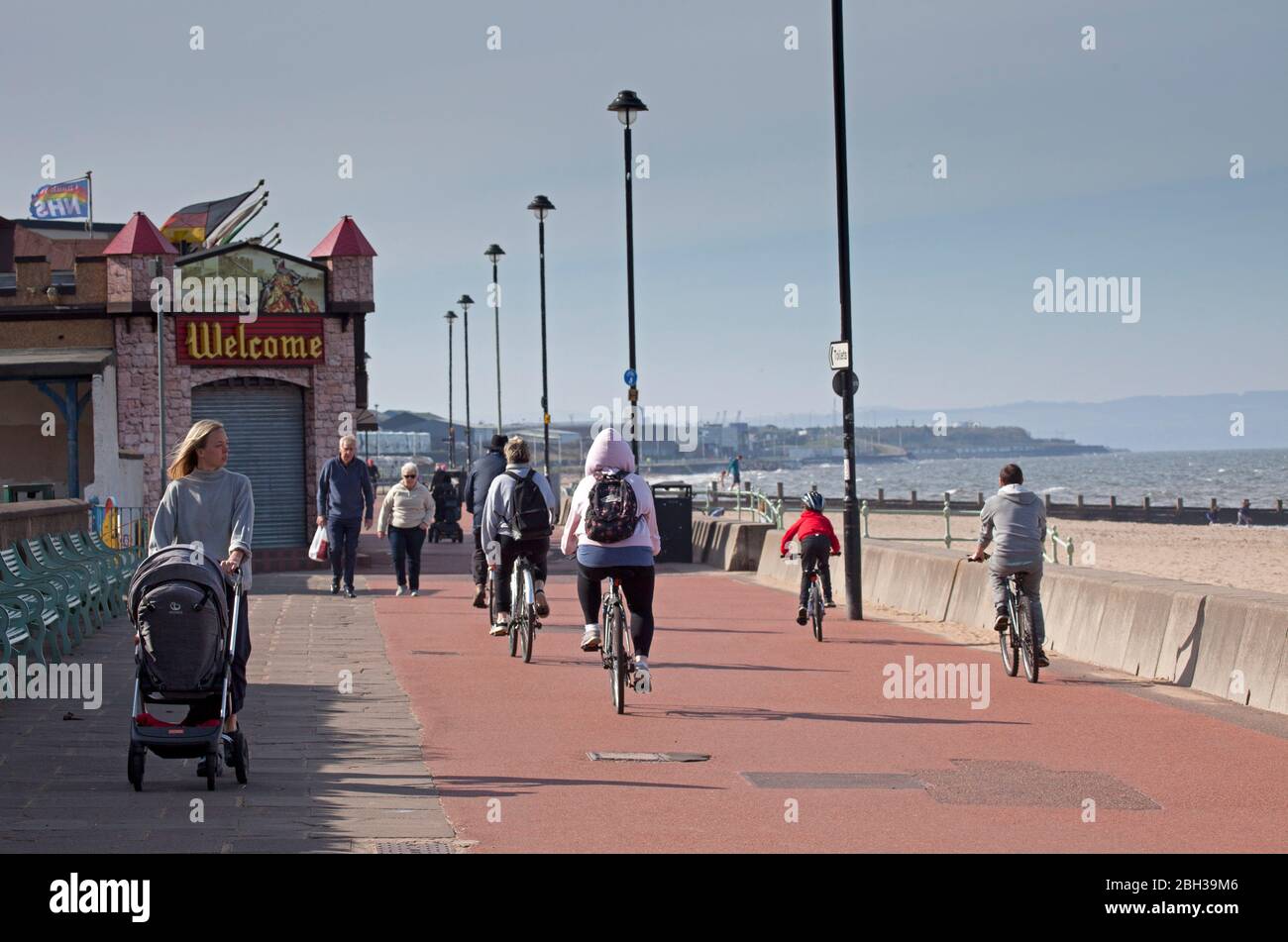 Portobello, Edimburgo, Scozia, Regno Unito. 23 aprile 2020. Pomeriggio soleggiato ma ventilato. Più persone locali si avventurano verso il mare forse incoraggiati dal sole a svolgere il loro esercizio quotidiano permesso, ancora quasi tanti ciclisti come i pedoni sulla Promenade. Foto Stock