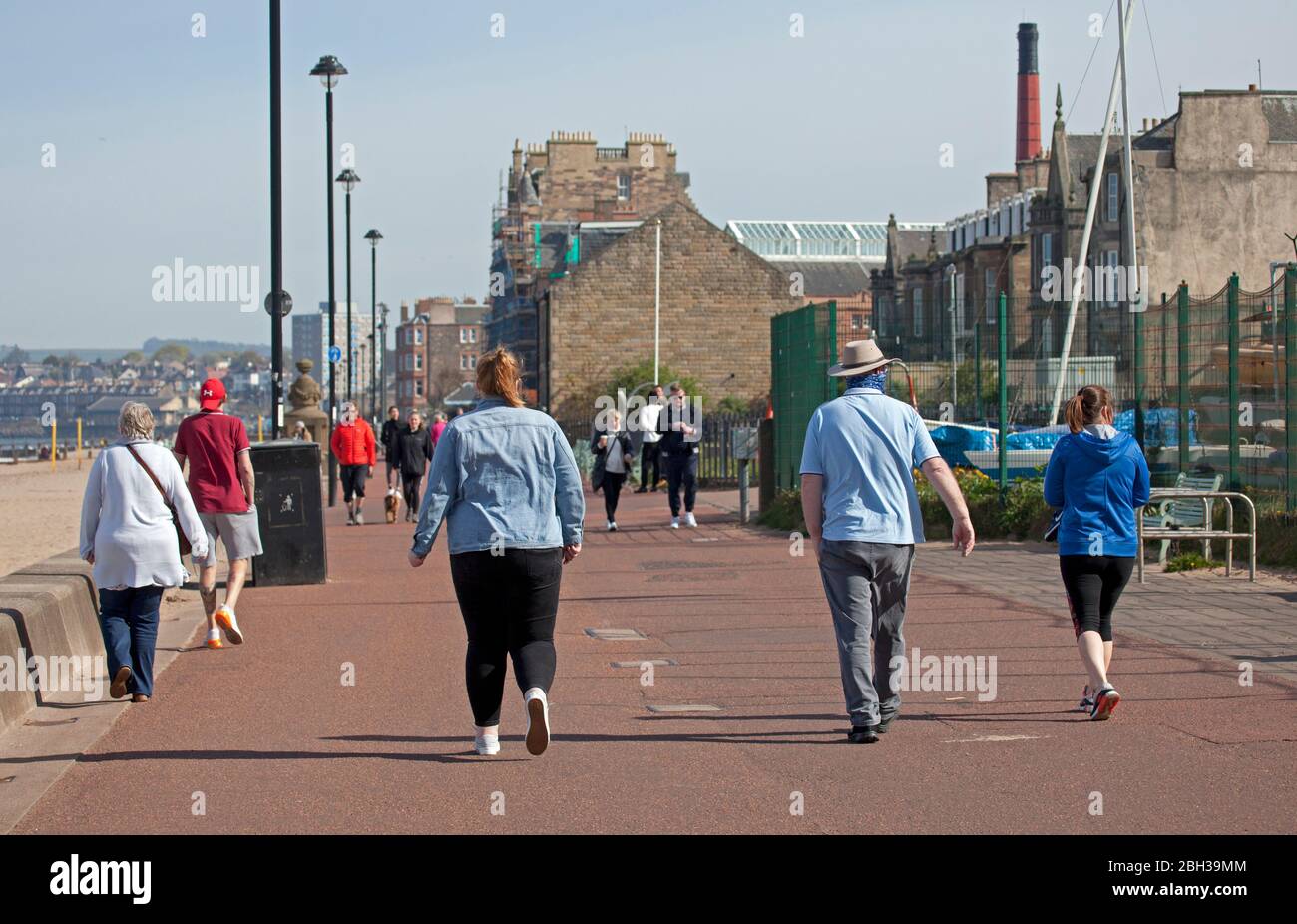 Portobello, Edimburgo, Scozia, Regno Unito. 23 aprile 2020. Pomeriggio soleggiato ma ventilato. Più persone locali si avventurano verso il mare forse incoraggiati dal sole a svolgere il loro esercizio quotidiano permesso, ancora quasi tanti ciclisti come i pedoni sulla Promenade. Foto Stock