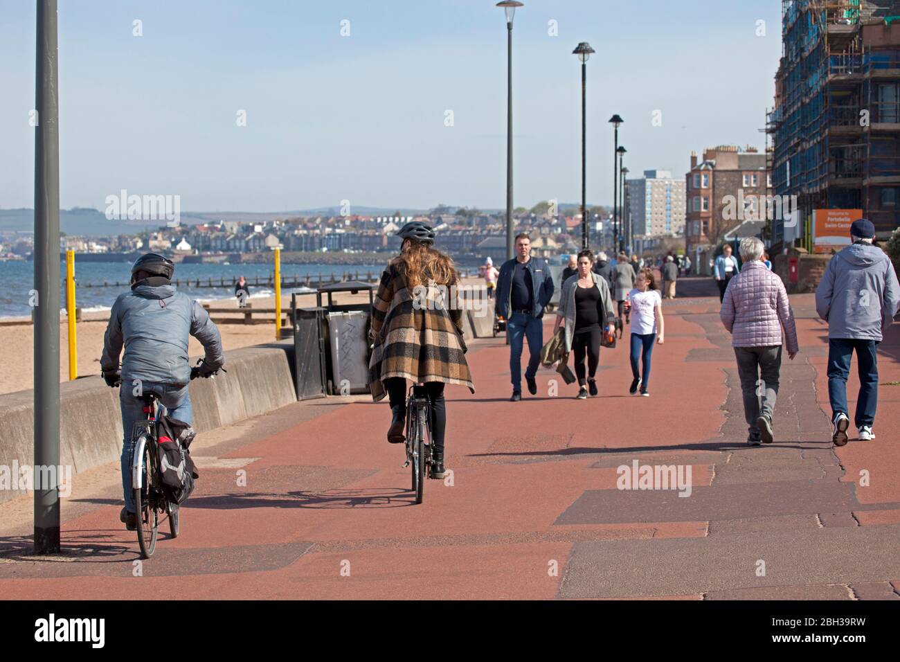 Portobello, Edimburgo, Scozia, Regno Unito. 23 aprile 2020. Pomeriggio soleggiato ma ventilato. Più persone locali si avventurano verso il mare forse incoraggiati dal sole a svolgere il loro esercizio quotidiano permesso, ancora quasi tanti ciclisti come i pedoni sulla Promenade. Foto Stock