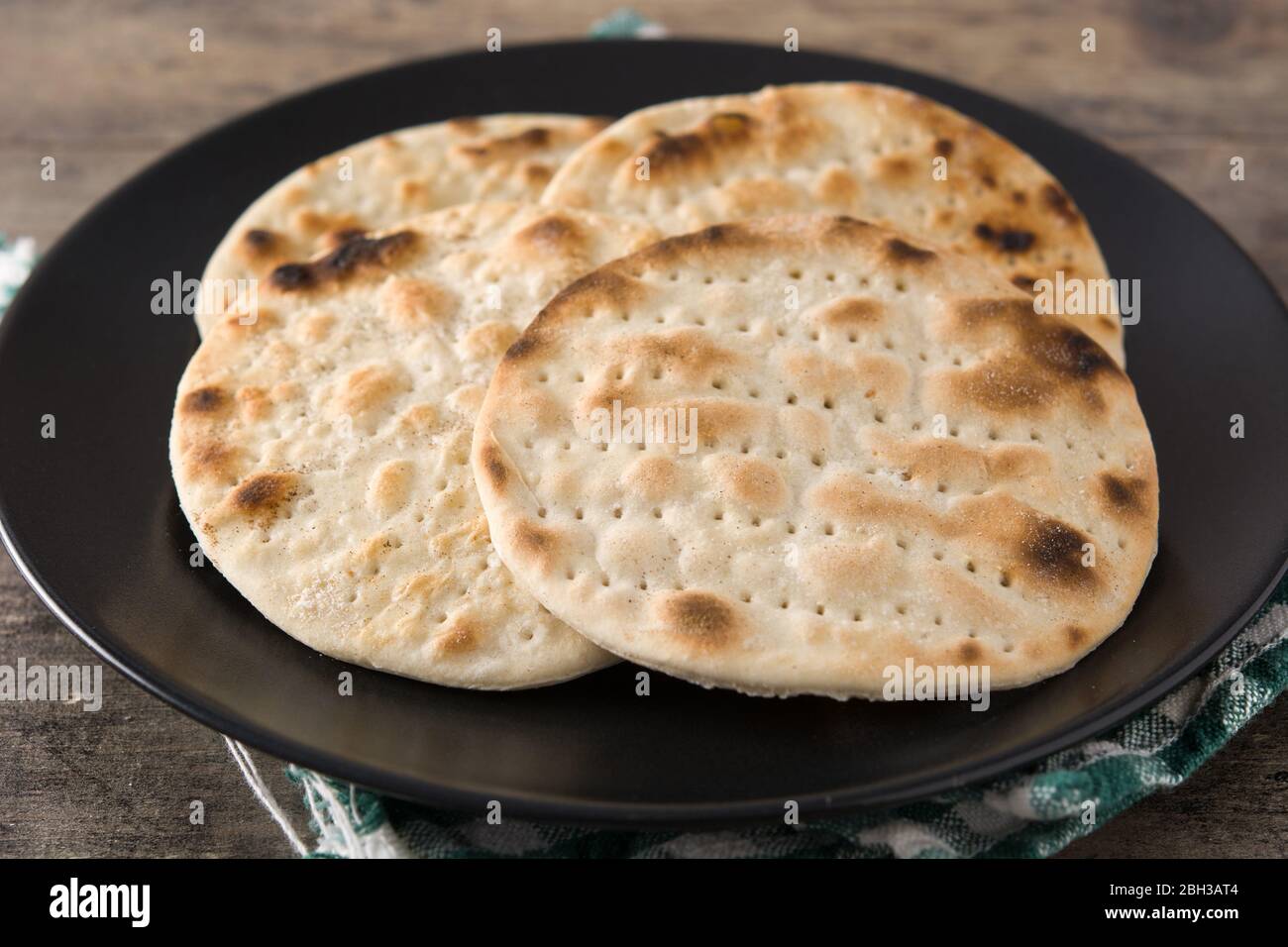 Matzah fatto a mano per la Pasqua ebraica su tavola di legno. Primo piano Foto Stock