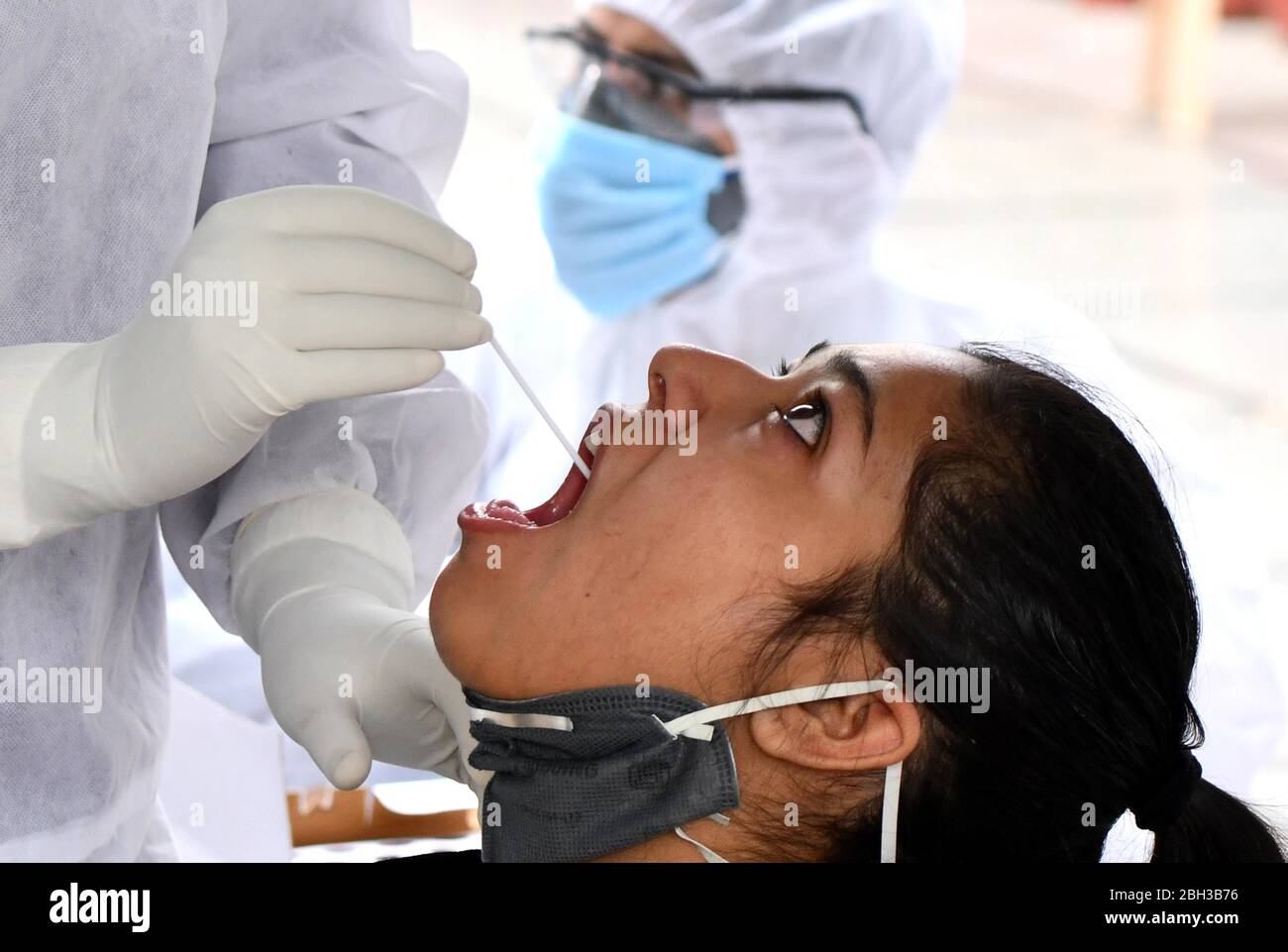 (200423) -- NUOVA DELHI, 23 aprile 2020 (Xinhua) -- un operatore sanitario raccoglie campioni di tampone da una donna per il test COVID-19 presso un centro di raccolta a Nuova Delhi, India, il 23 aprile 2020. (Foto di Partha Sarkar/Xinhua) Foto Stock