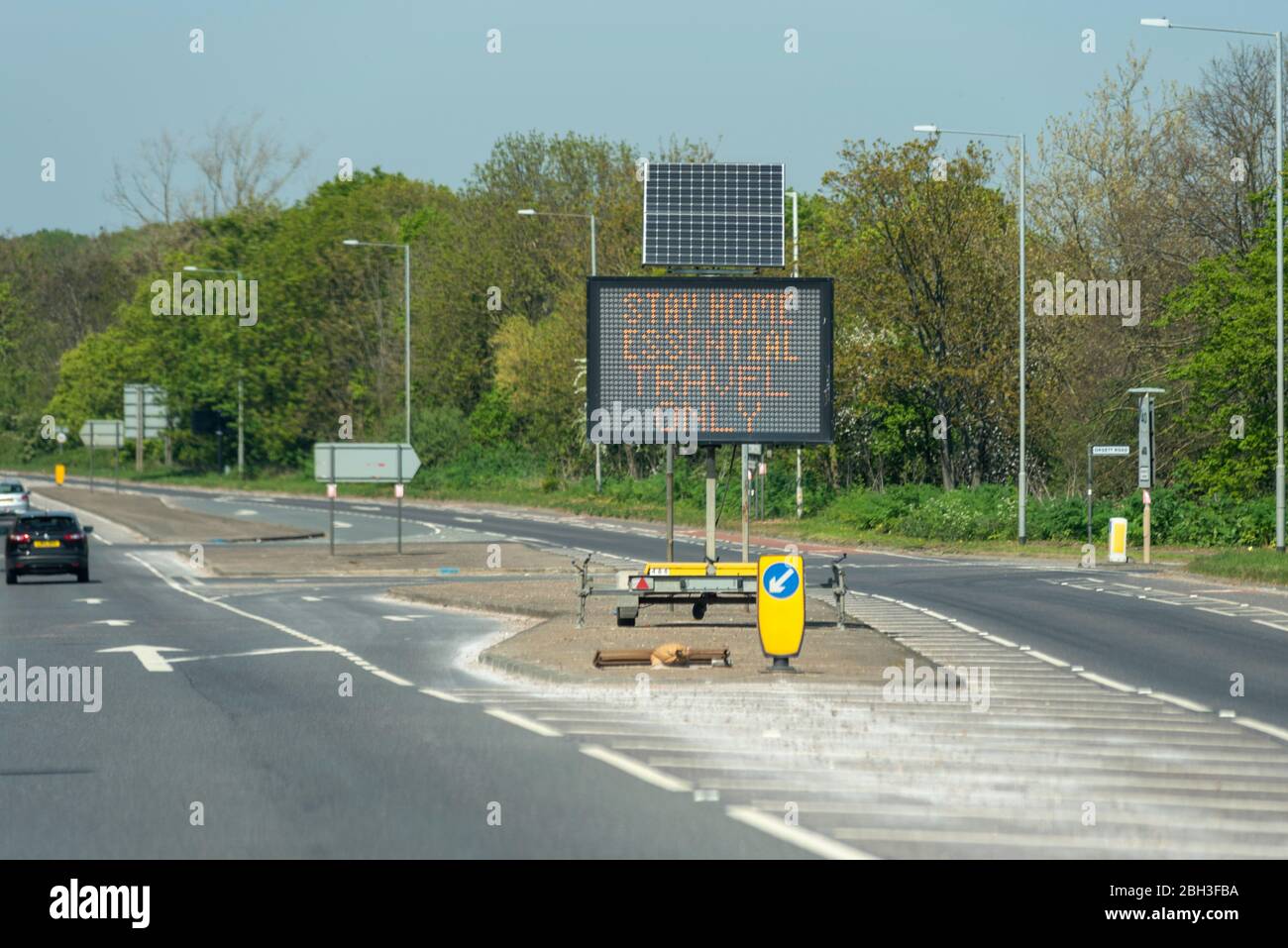 Segnale matrice di traffico sulla A128 vicino all'ospedale Orsett, Essex che chiede alle persone di rimanere a casa, viaggio essenziale solo, durante la pandemia di Coronavirus COVID-19 Foto Stock
