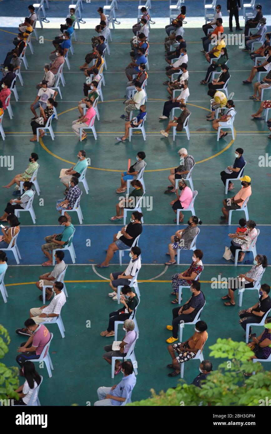 La gente siede a distanza sociale mentre aspettano gli articoli durante l'evento.Wat Rakhang Khositaram un monastero monaco tailandese dà al pubblico generale e personale medico dell'ospedale Siriraj. A causa della chiusura a seguito dell'epidemia di Covid-19, molte persone vivono senza reddito ed economicamente colpite. Foto Stock