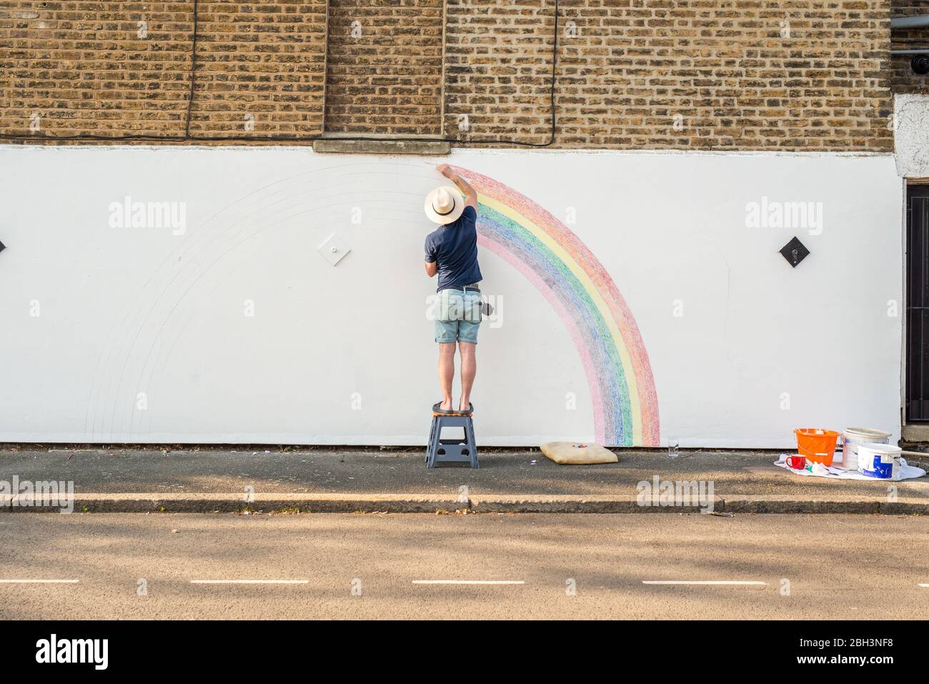Camberwell, Londra, Regno Unito. 23 aprile 2020. Louis Young disegna un murale di un arcobaleno sul muro della sua casa per ringraziarvi al NHS per aver preso cura di suo padre. Suo padre è uscito dall'ospedale oggi dopo settimane di malattia polmonare ma non correlata a covid-19. Credit: Tom Leighton/Alamy Live News Foto Stock
