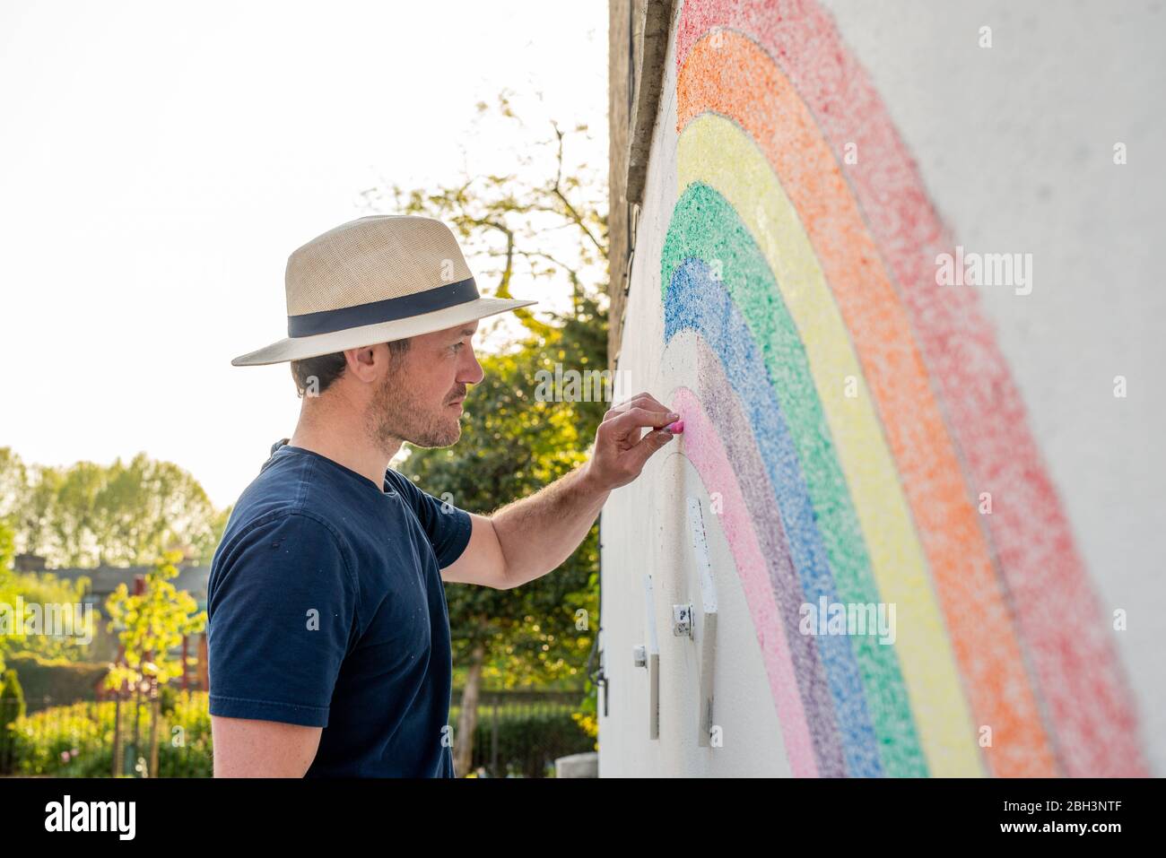 Camberwell, Londra, Regno Unito. 23 aprile 2020. Louis Young disegna un murale di un arcobaleno sul muro della sua casa per ringraziarvi al NHS per aver preso cura di suo padre. Suo padre è uscito dall'ospedale oggi dopo settimane di malattia polmonare ma non correlata a covid-19. Credit: Tom Leighton/Alamy Live News Foto Stock