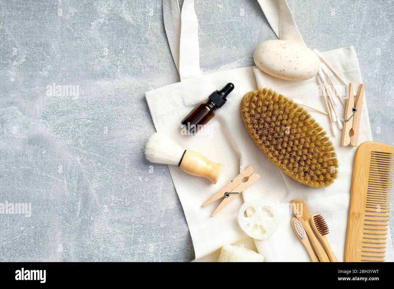 Accessori bagno con prodotto igiene personale e borsa in tela su tavolo in pietra. Vista dall'alto, disposizione piatta. Trattamento SPA a casa, concetto di cura del corpo Foto Stock