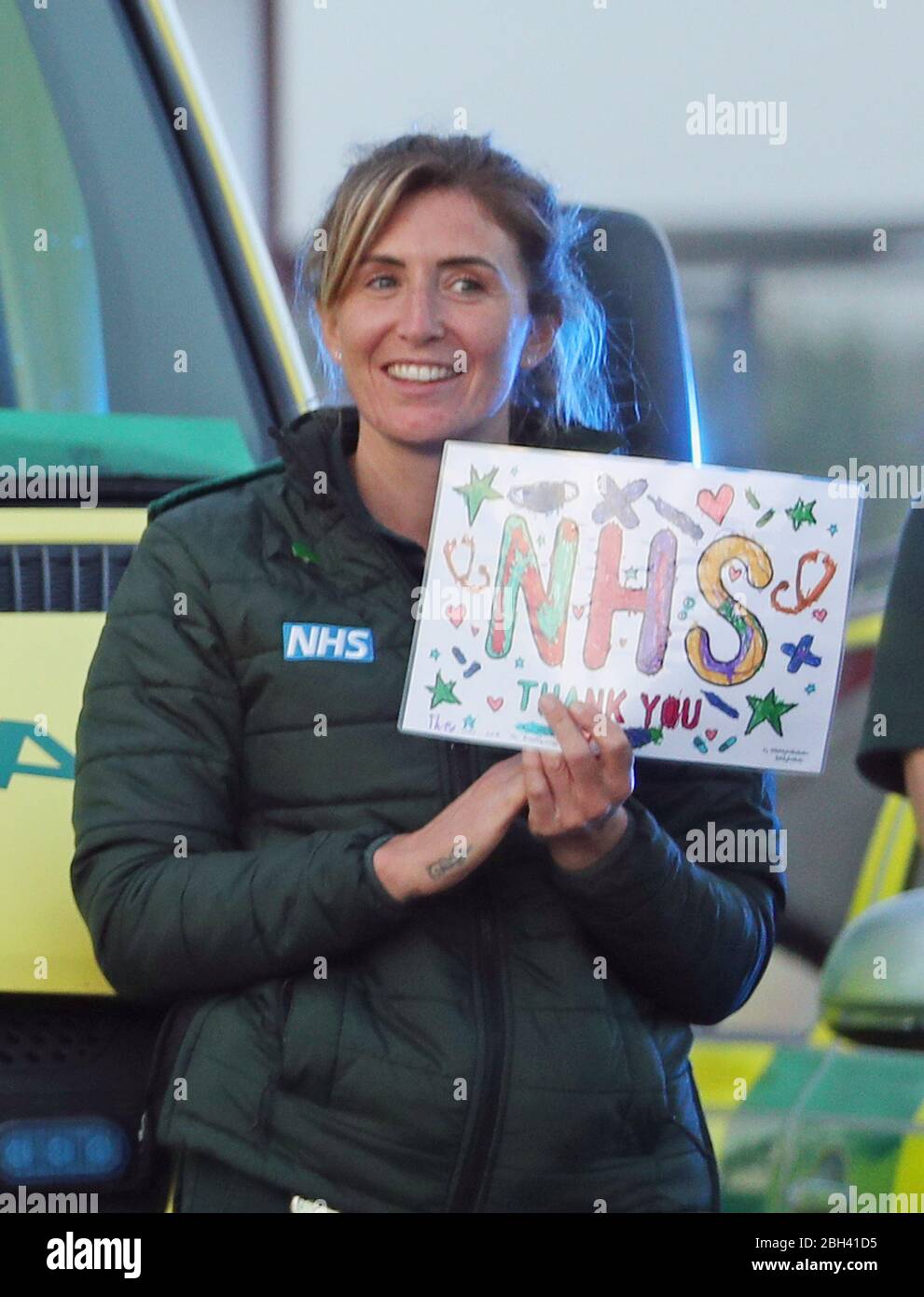 Un paramedico al di fuori del Royal Bournemouth Hospital si unisce agli applausi per salutare gli eroi locali durante l'iniziativa Clap for Carers di Giovedi a livello nazionale per riconoscere e sostenere i lavoratori e gli operatori del NHS che combattono la pandemia di coronavirus. Foto Stock