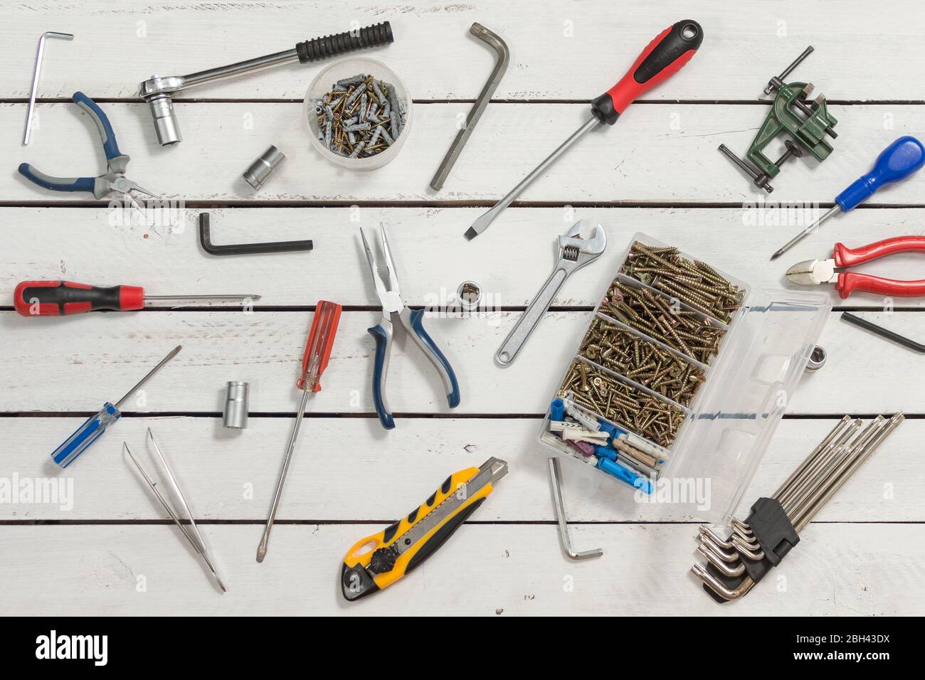Gli utensili di falegname si stendono su un tavolo di legno fatto di tavole bianche. Foto Stock