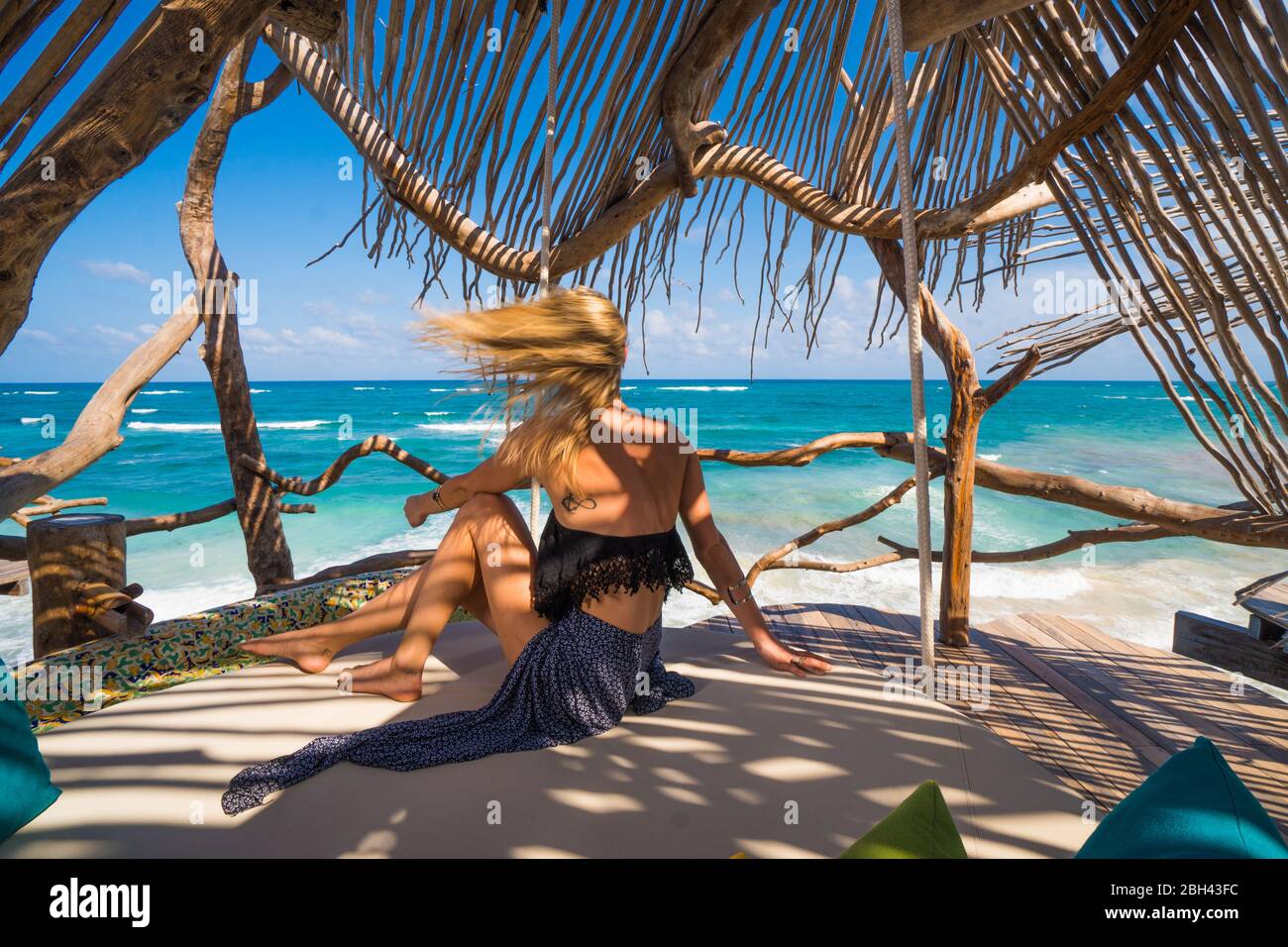 Capelli donna ondeggiante nel vento che si affaccia sull'oceano tropicale Foto Stock