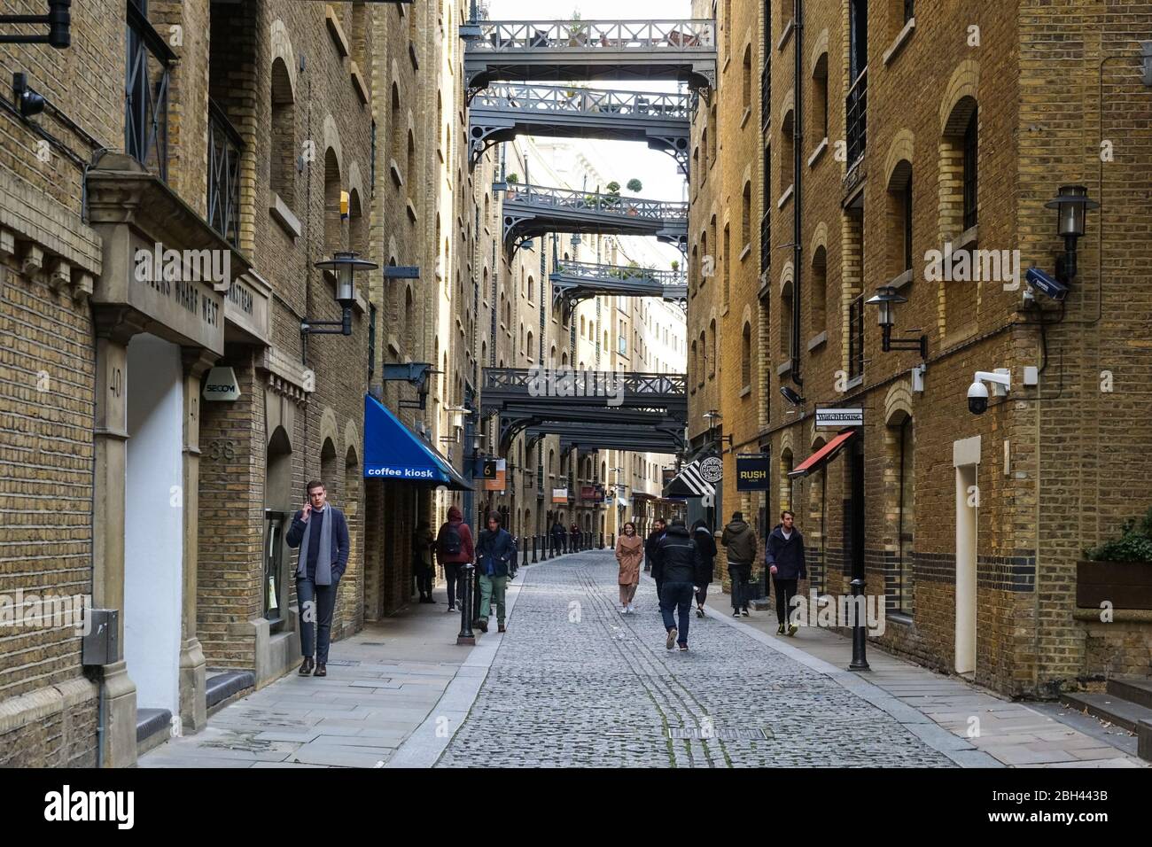 Gente di Shad Thames, una storica strada acciottolata lungo il fiume con a Bermondsey con appartamenti convertiti in magazzini, Londra, Inghilterra Regno Unito Foto Stock