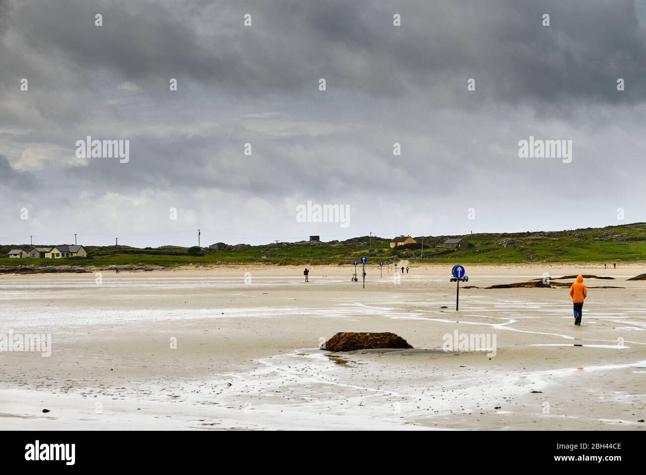 Il grande tratto di sabbia per raggiungere l'isola di Omey seguendo le indicazioni della freccia. L'isola di Omey è un'isola di marea situata vicino a Claddaghduff sulla ed occidentale Foto Stock