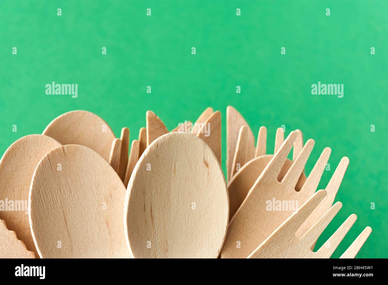 Posate eco di pino. Stoviglie monouso in materiali naturali. Cucchiaio di legno, forchetta e coltello su sfondo grecato. Foto Stock