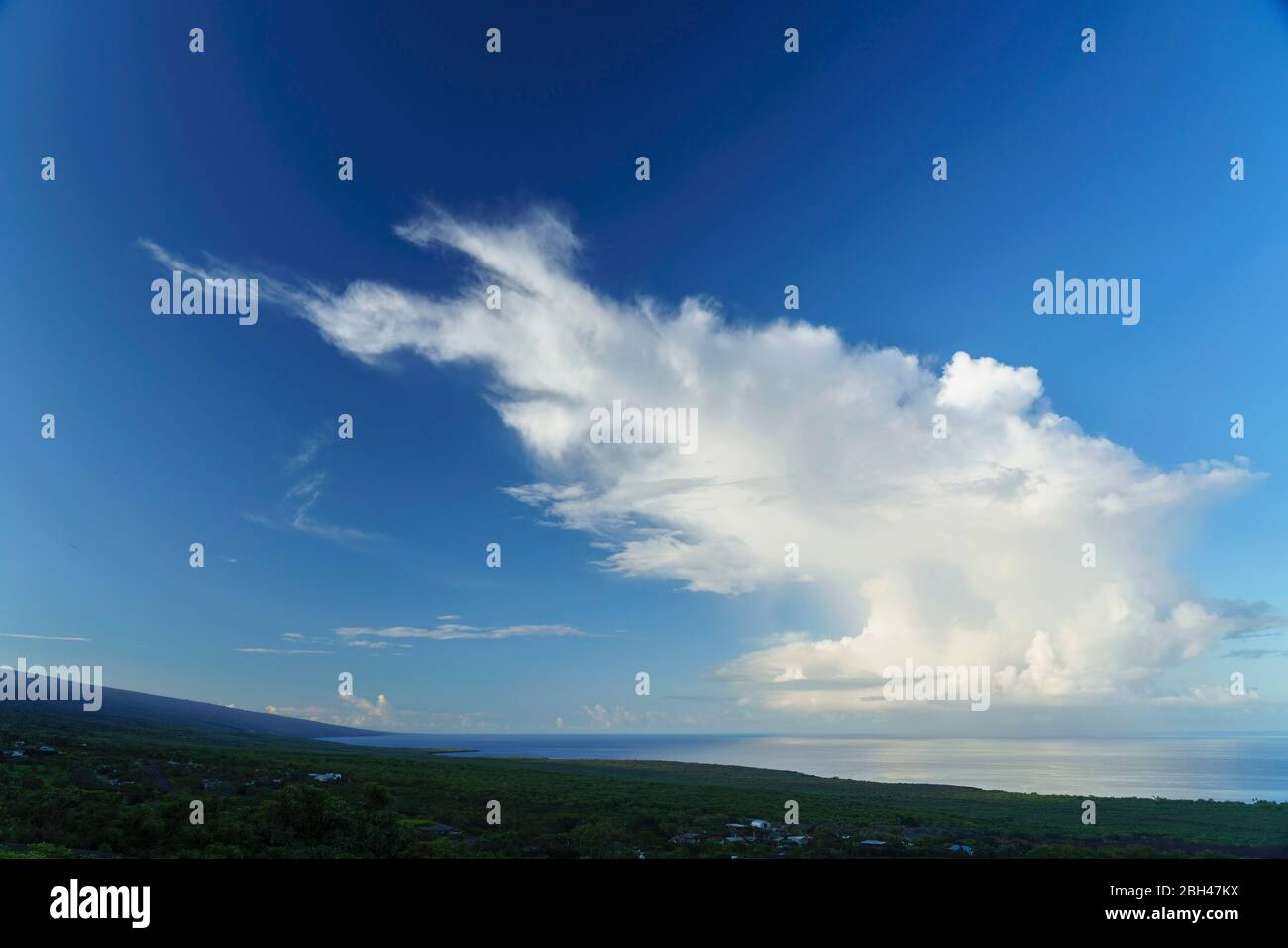 Cumulus Cloud guardando lungo la costa sud di Kona in Hawaii con Mauna Loa che sorge dal mare a sinistra . Foto Stock