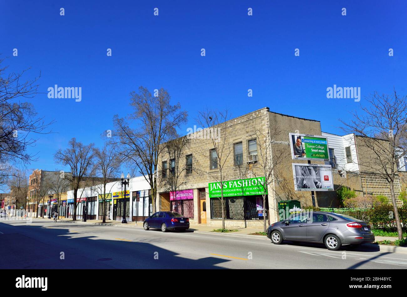 Chicago, Illinois, Stati Uniti. Alcune auto parcheggiate e un ciclista solitaria sono tutte che abitano una strada tutta ma deserta nel quartiere della città di Lake View. Foto Stock