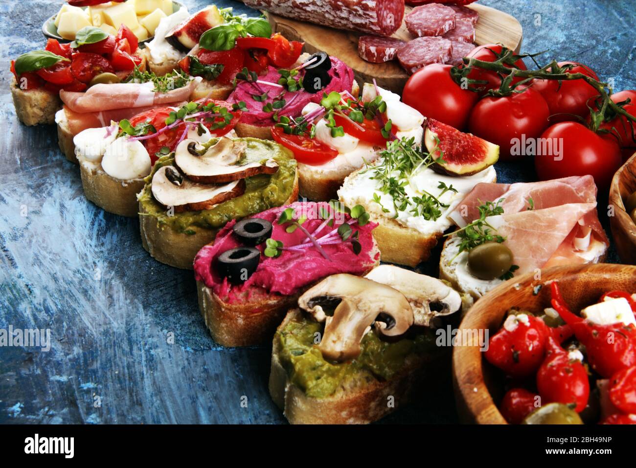 Bruschette assortite con vari condimenti. Bruschetta appetitosa o crostini crudo. Varietà di piccoli panini. Mescolare la bruschetta Foto Stock