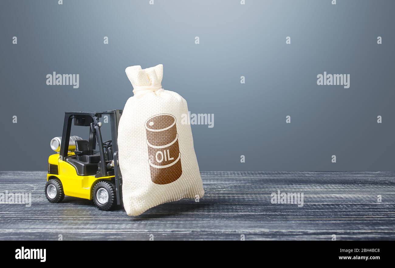 Un carrello elevatore a forche porta un sacchetto con l'icona di un barile d'olio. Commercio e trasporto di petrolio. Acquisto futures per la vendita. Mancanza di spazio di immagazzinamento e di eccesso di fornitura. Bassa Foto Stock