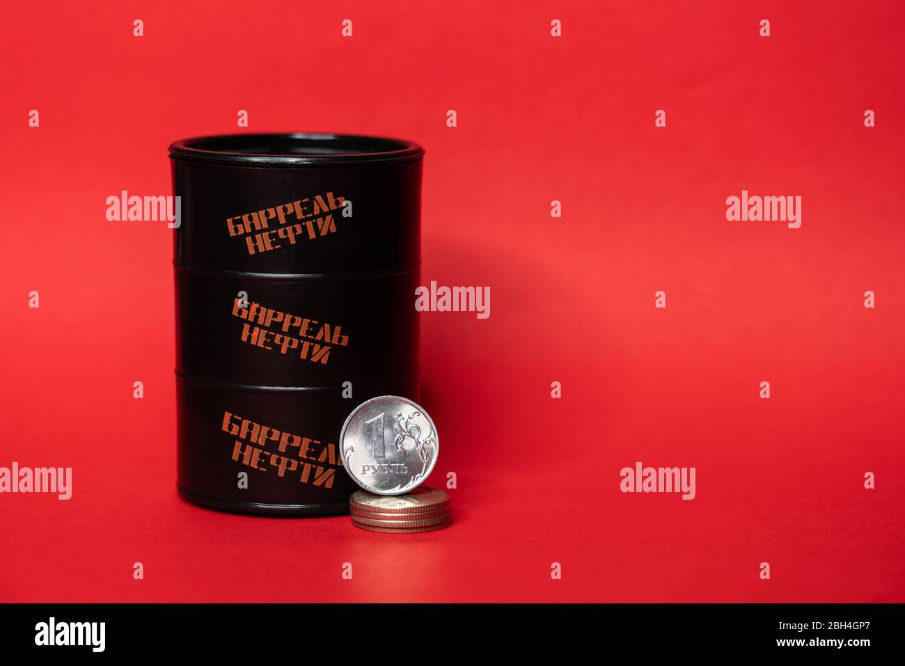 Barile nero con una moneta ruble su sfondo rosso. Il prezzo al barile del petrolio scende sotto grafico. Andamento del mercato petrolifero. Infografica sul petrolio. Foto Stock