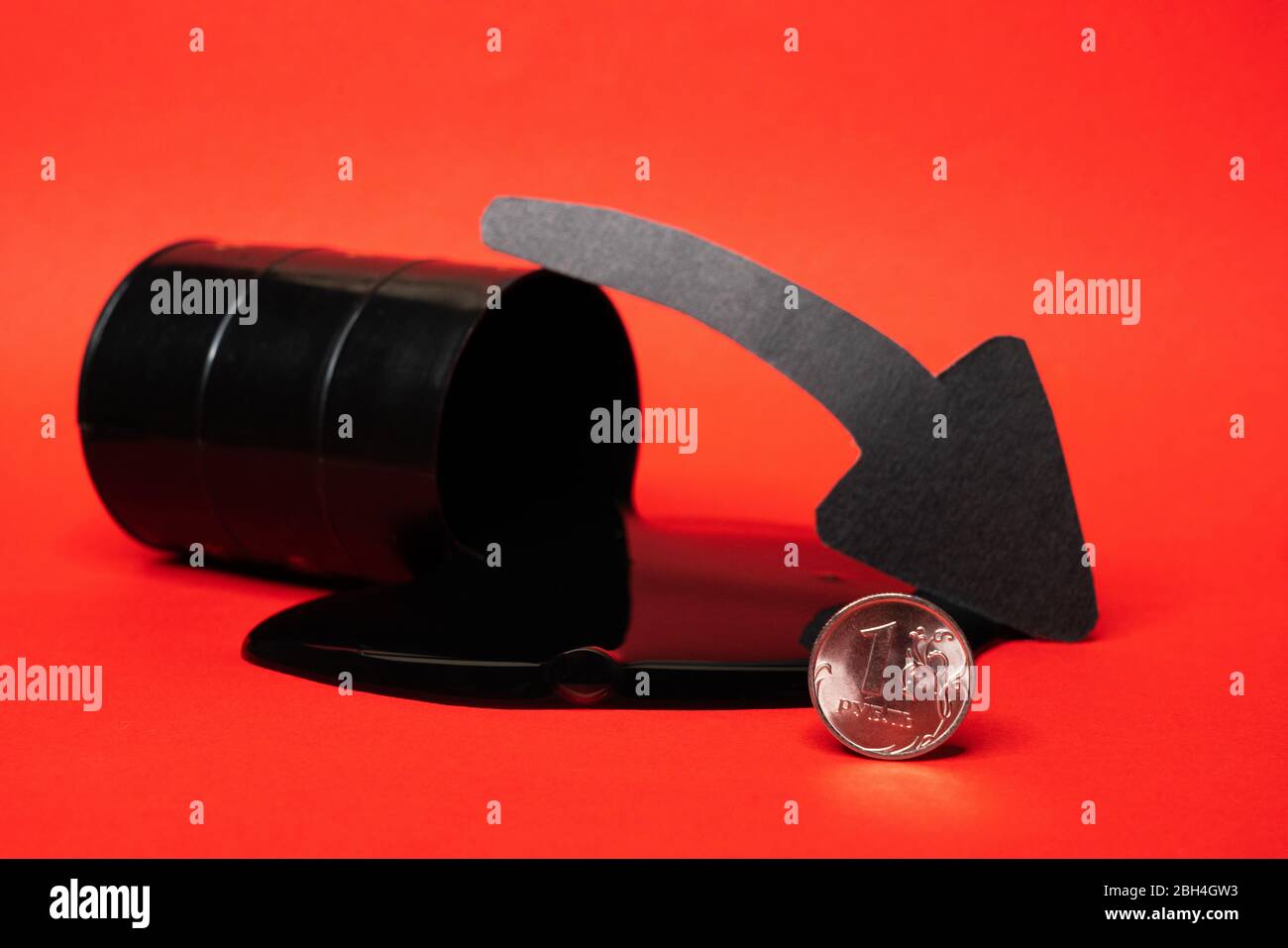 olio che fuoriesce dal barile con una moneta rubla e una freccia giù su uno sfondo rosso. Il prezzo al barile del petrolio scende sotto grafico. Andamento del mercato petrolifero. Petrolio Foto Stock