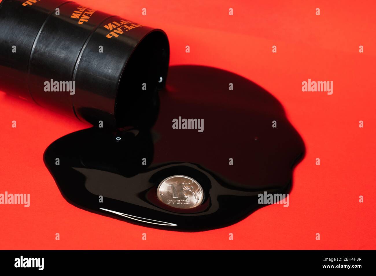 olio che fuoriesce dal barile con una moneta da un rublo su sfondo rosso. Il prezzo al barile del petrolio scende sotto grafico. Andamento del mercato petrolifero. Infografica sul petrolio. Foto Stock