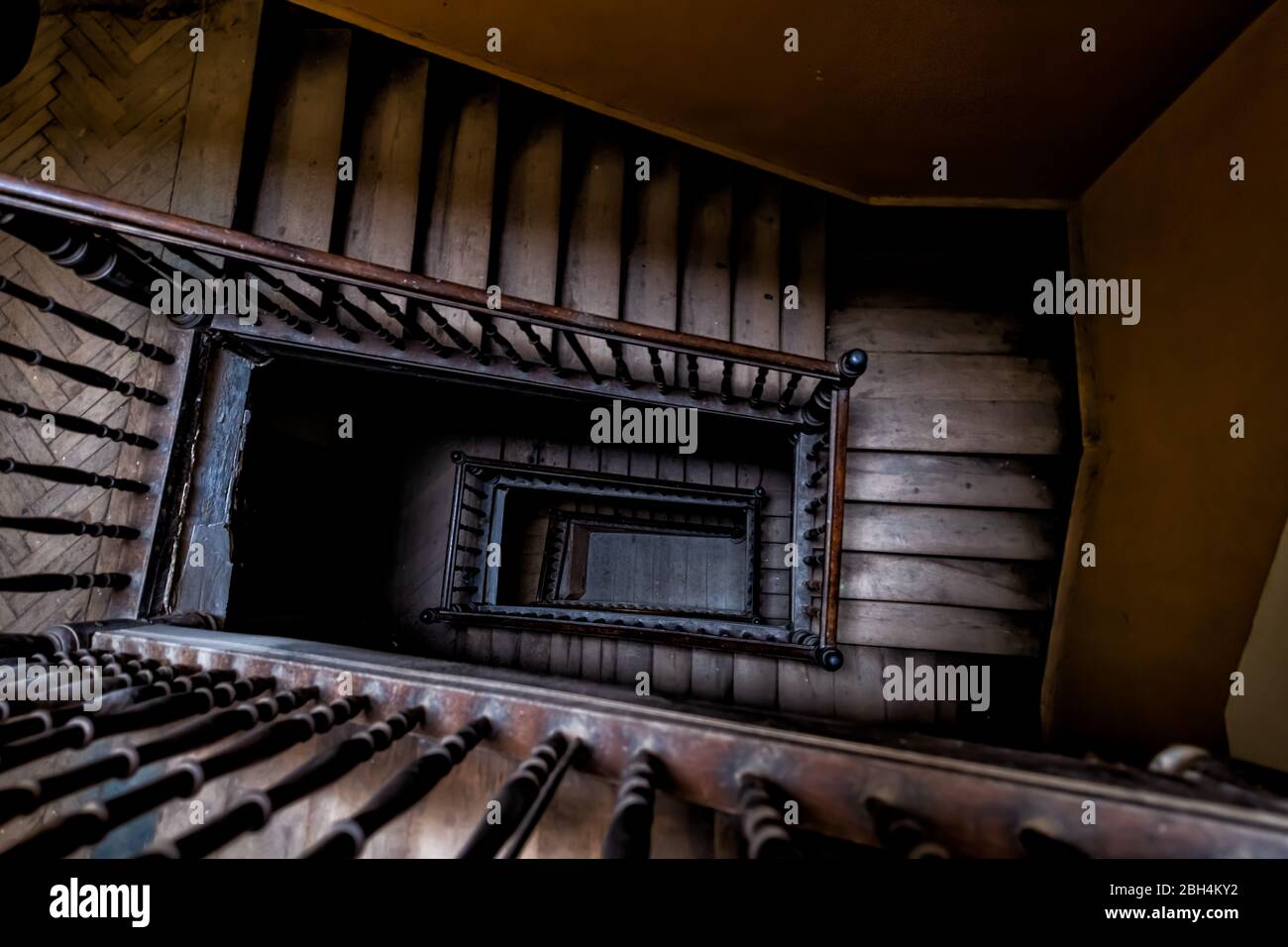Alto angolo aereo sopra vista giù di vecchia scala vintage chiocciola a Lviv, Ucraina, Europa con nessuno architettura scuro basso-chiave abstract patt Foto Stock