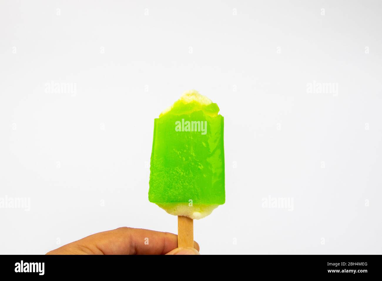 Mano dell'uomo che tiene il gelato Possicle gusto di lime su sfondo bianco. Foto Stock