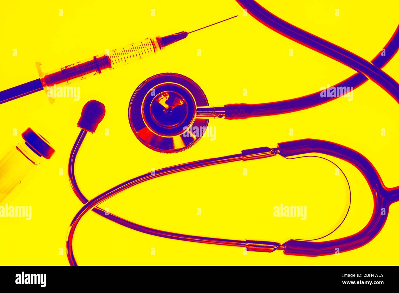 Stetoscopio, ago e vile su sfondo giallo Foto Stock