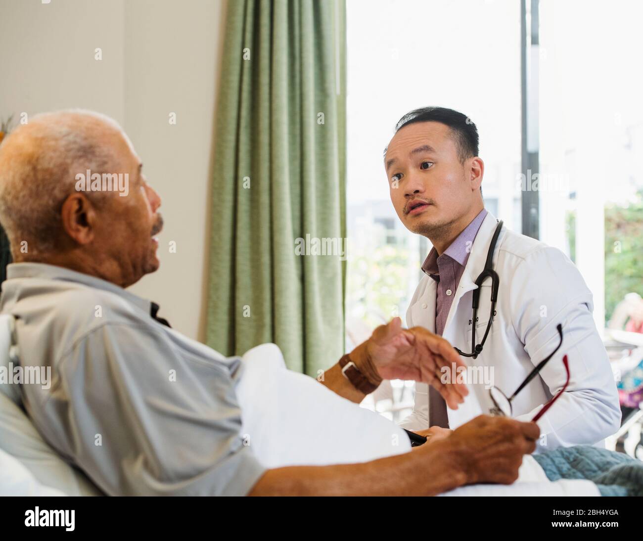 Uomo anziano che parla con il medico Foto Stock