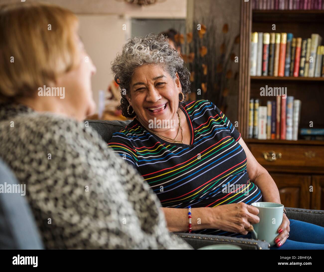 Sorridente donna anziana che tiene la tazza Foto Stock
