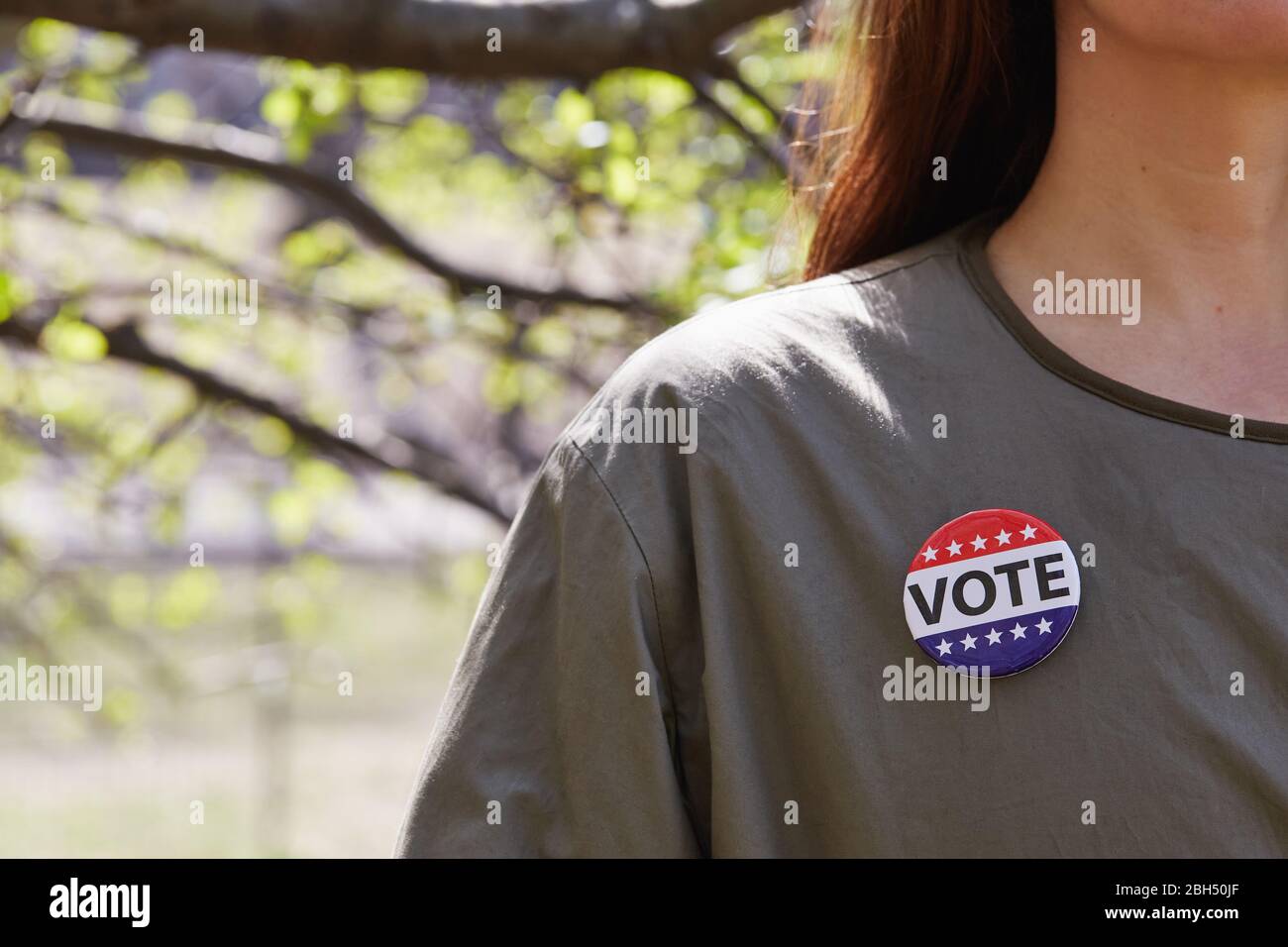 Donna con pulsante di voto sulla sua parte superiore Foto Stock