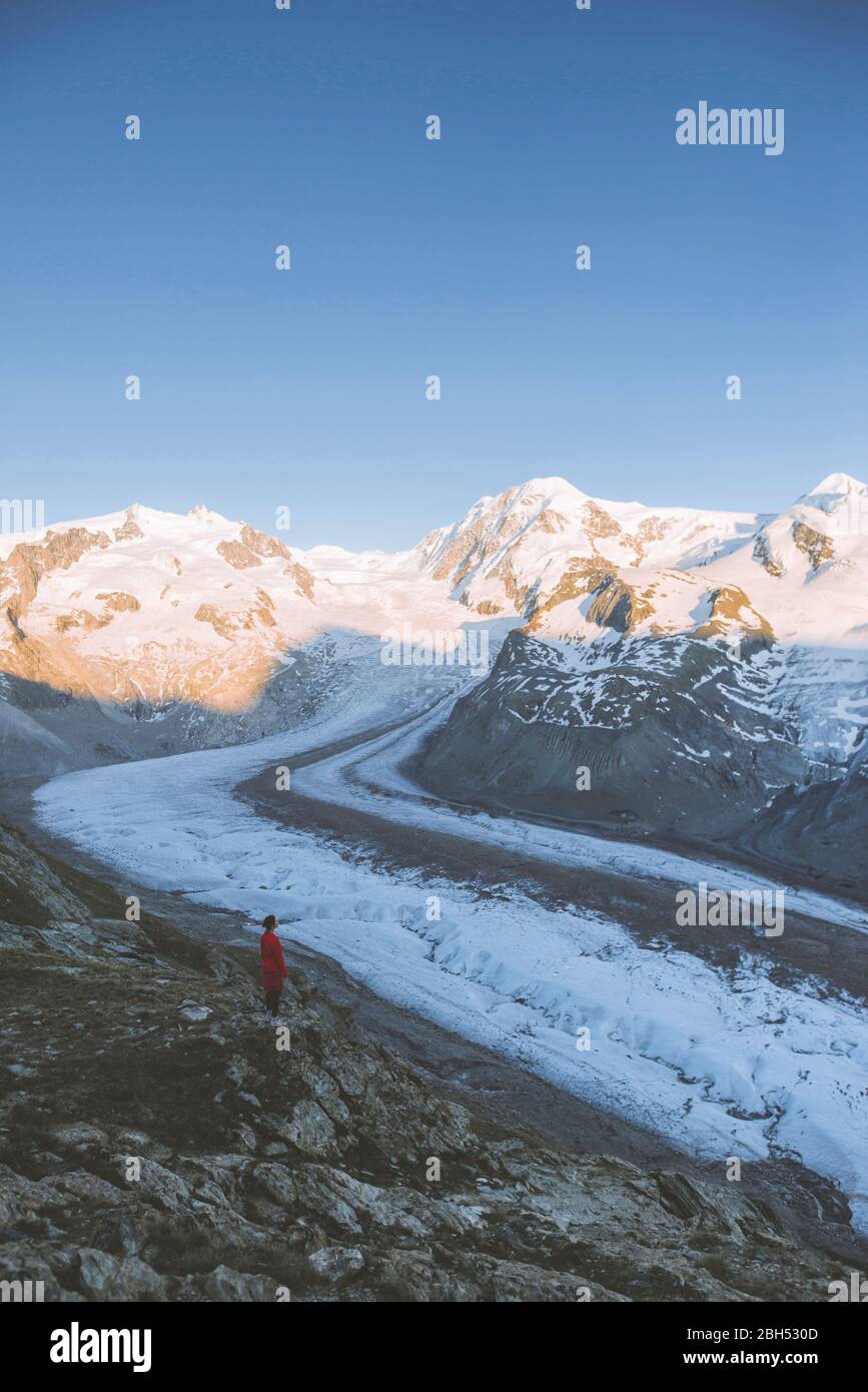 Donna in piedi sulla roccia del Ghiacciaio Gorner in Vallese, Svizzera Foto Stock