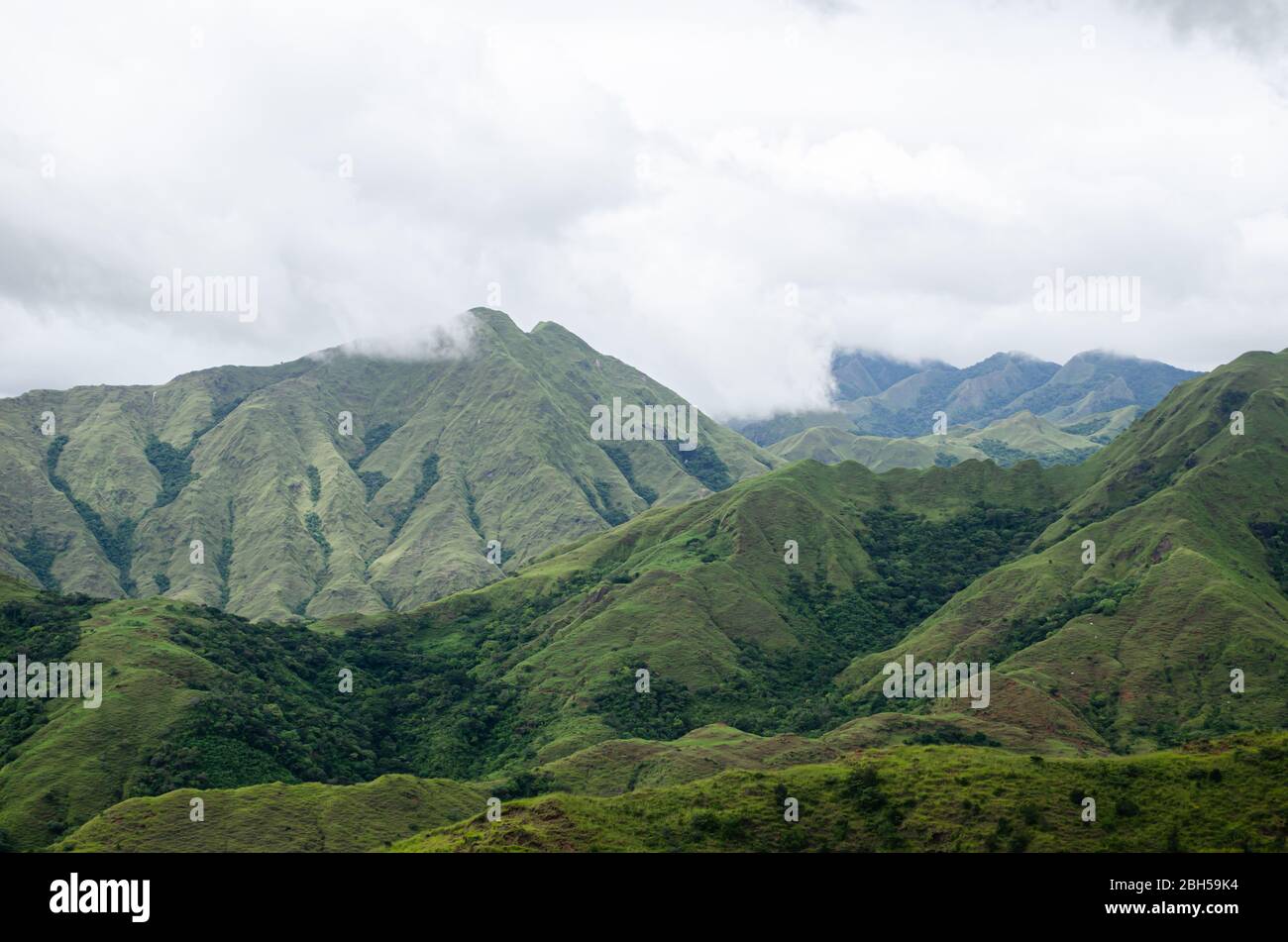 Vista panoramica del pittoresco paesaggio montano nel centro di Panama, con lussureggianti colline verdi sotto un cielo nuvoloso. Foto Stock
