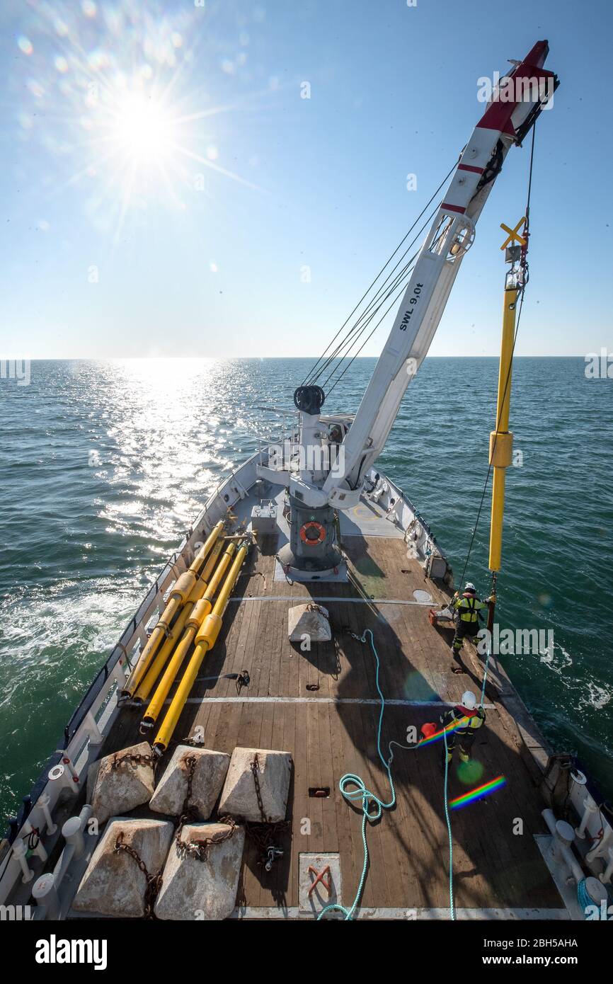 23 aprile 2020, Schleswig-Holstein, Helgoland: Una tonnellata è abbassata nell'acqua con l'aiuto di una gru. Segnale di partenza per un grande campo di test marittimo al largo di Helgoland: Gli scienziati del Centro di test per le tecnologie marittime hanno utilizzato tonnellate per contrassegnare un'area di tre milioni di metri quadrati non lontano dall'isola del Mare del Nord. Esso è destinato a fornire in futuro impianti di prova per la robotica marittima. Produttori e scienziati possono testare diversi scenari. Ad esempio, i veicoli subacquei autonomi per turbine eoliche offshore possono essere testati in condizioni reali in mare o droni flyi Foto Stock