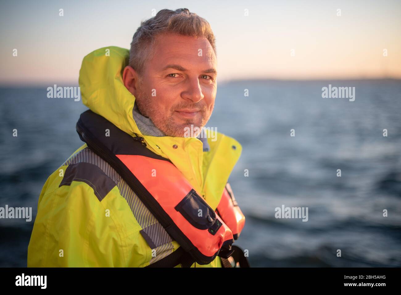 23 aprile 2020, Schleswig-Holstein, Helgoland: Hanno Schnars, responsabile della business unit Maritime Technologies presso l'Istituto Frauenhofer per la tecnologia di produzione e la ricerca sui materiali applicati (IFAM), è in piedi al railing del boa strato 'Lev Taifun' nella prima mattina. Segnale di partenza per un grande campo di test marittimo al largo di Helgoland: Gli scienziati del Centro di test per le tecnologie marittime hanno utilizzato tonnellate per contrassegnare un'area di tre milioni di metri quadrati non lontano dall'isola del Mare del Nord. Esso è destinato a fornire in futuro impianti di prova per la robotica marittima. Produttori e sci Foto Stock