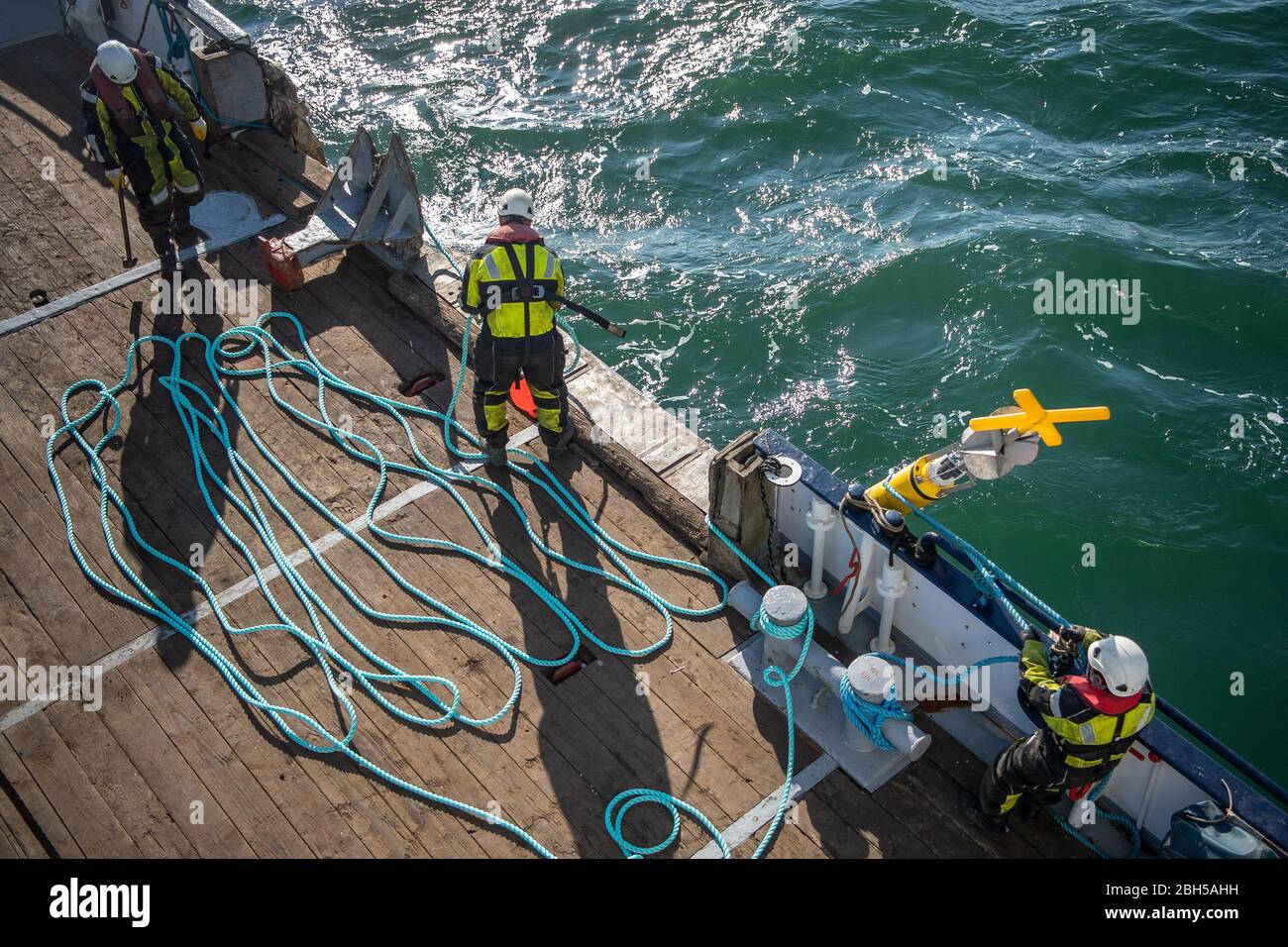 23 aprile 2020, Schleswig-Holstein, Helgoland: I lavoratori preparano la corda per una tonnellata. Segnale di partenza per un grande campo di test marittimo al largo di Helgoland: Gli scienziati del Centro di test per le tecnologie marittime hanno utilizzato tonnellate per contrassegnare un'area di tre milioni di metri quadrati non lontano dall'isola del Mare del Nord. Esso è destinato a fornire in futuro impianti di prova per la robotica marittima. Produttori e scienziati possono testare diversi scenari. Ad esempio, i veicoli subacquei autonomi per turbine eoliche offshore possono essere testati in condizioni reali in mare o droni che volano sull'acqua per Foto Stock