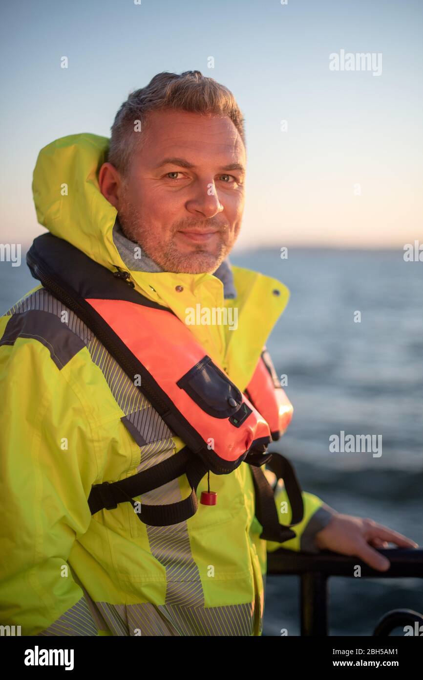 23 aprile 2020, Schleswig-Holstein, Helgoland: Hanno Schnars, responsabile della business unit Maritime Technologies presso l'Istituto Frauenhofer per la tecnologia di produzione e la ricerca sui materiali applicati (IFAM), è in piedi al railing del boa strato 'Lev Taifun' nella prima mattina. Segnale di partenza per un grande campo di test marittimo al largo di Helgoland: Gli scienziati del Centro di test per le tecnologie marittime hanno utilizzato tonnellate per contrassegnare un'area di tre milioni di metri quadrati non lontano dall'isola del Mare del Nord. Esso è destinato a fornire in futuro impianti di prova per la robotica marittima. Produttori e sci Foto Stock