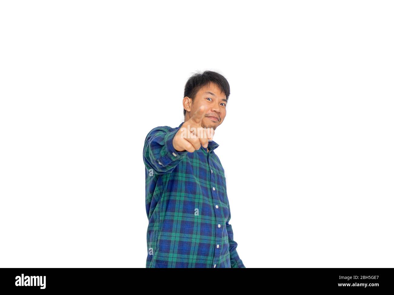 L'Asian disordinato uomo in blu plaid shirt è rivolta verso la telecamera in studio con la sua mano. Foto Stock
