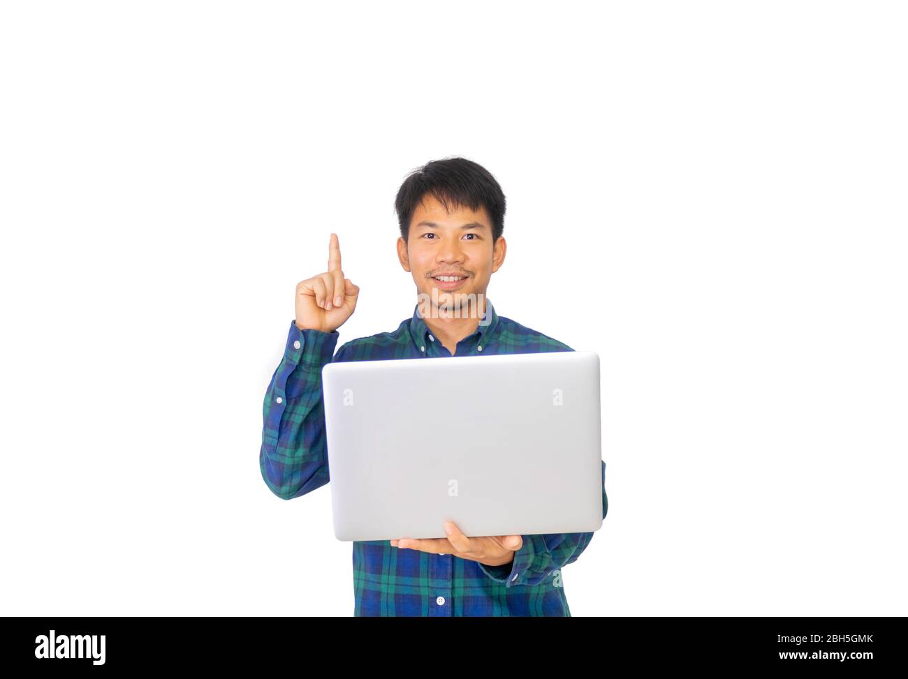 L'Asian disordinato uomo in blu plaid shirt è in possesso di un computer portatile sulla sua mano sinistra e rivolta verso lo spazio overhead.. Foto Stock