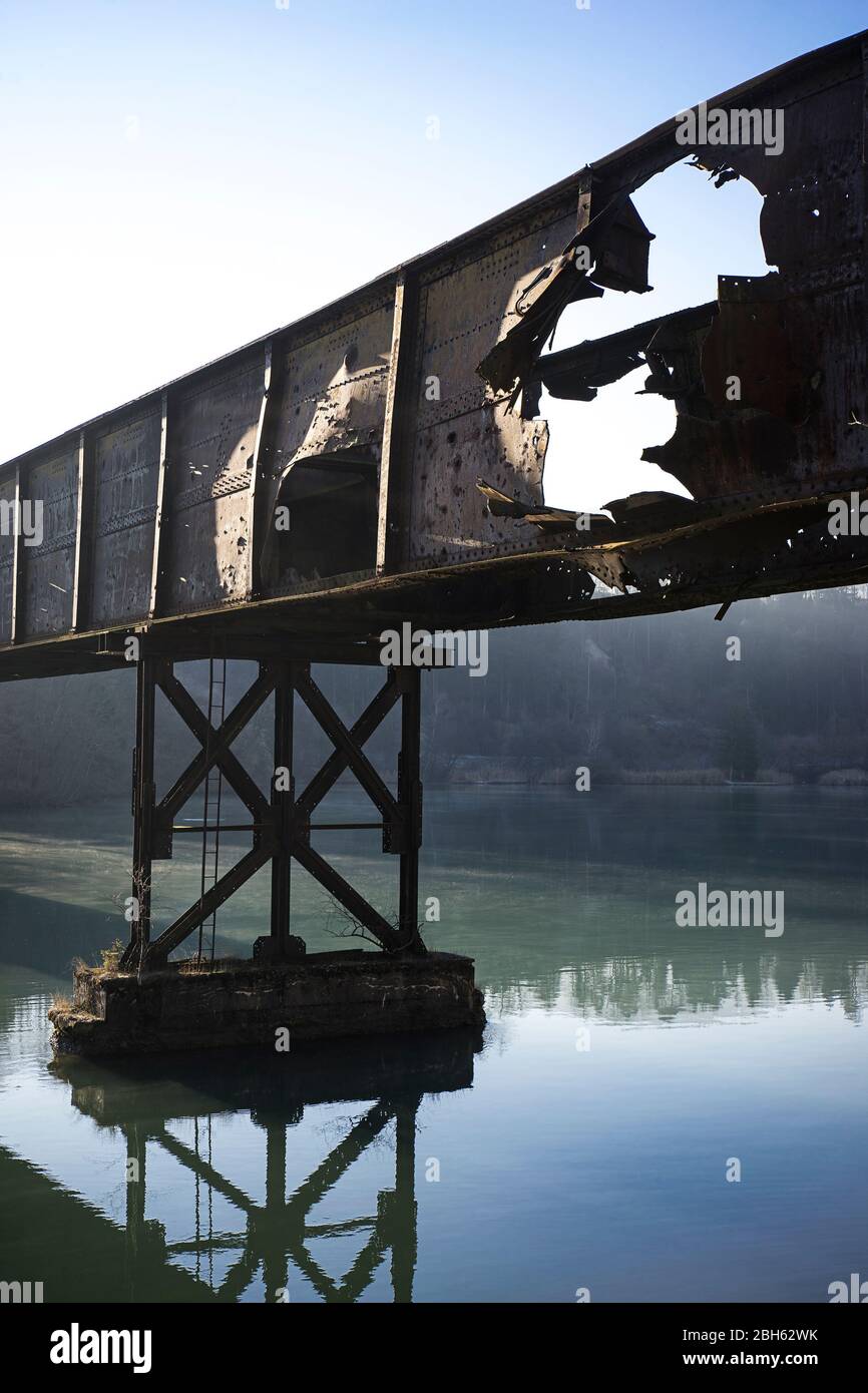 Vecchio ponte ferroviario danneggiato sul fiume Drava. Foto Stock
