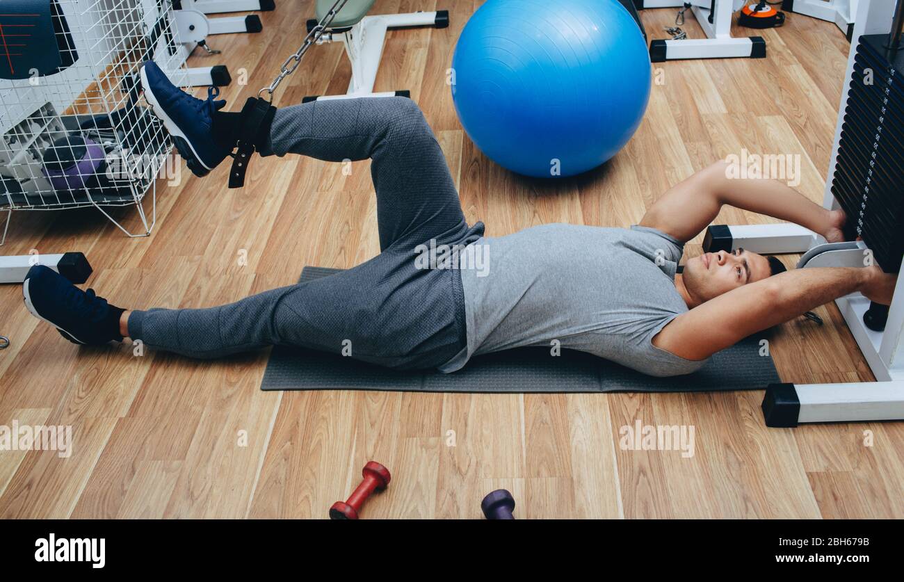 Atleta facendo in modo indipendente esercizi di kinesiterapia. Recupero del corpo e delle articolazioni dopo lesioni Foto Stock