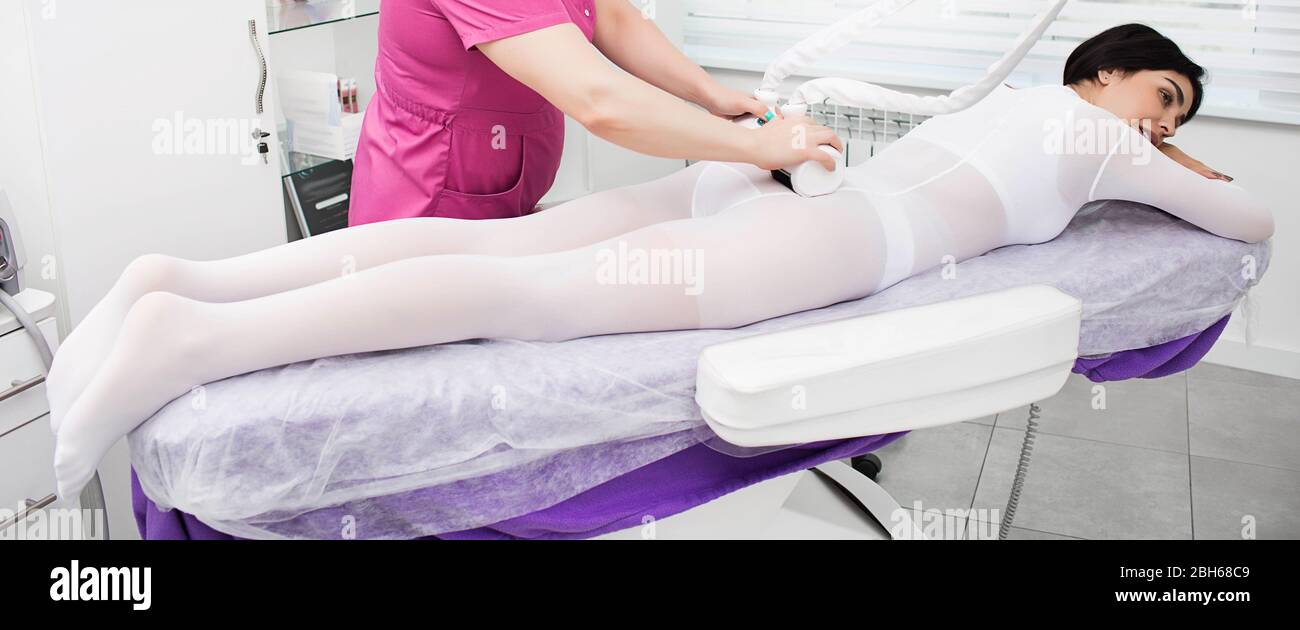 Rendendo sottile corpo con l'anti-cellulite massaggio GPL. donna vestito con una tuta speciale di ottenere una rimozione della cellulite massage Foto Stock