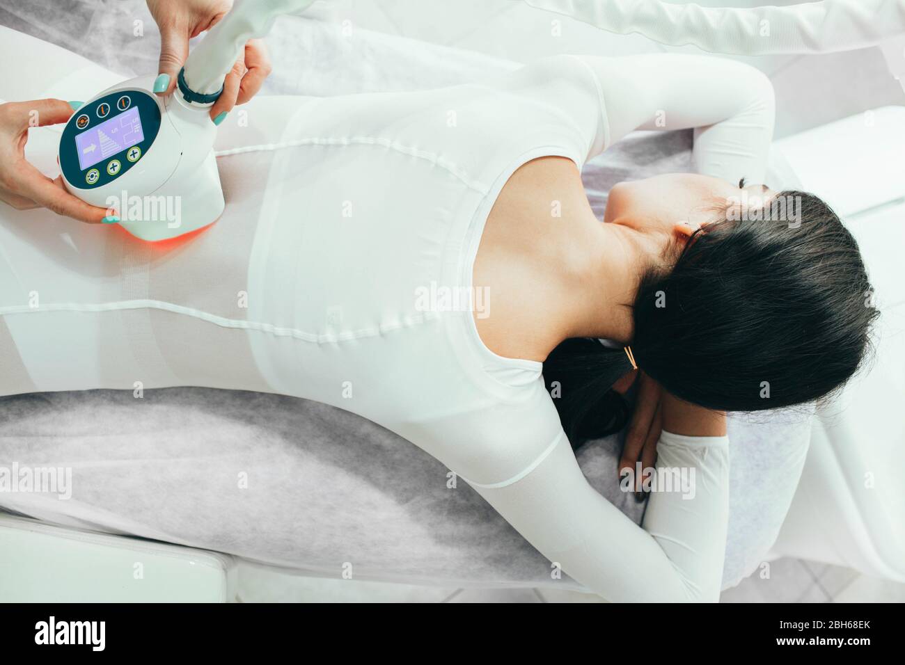Rendendo sottile corpo con l'anti-cellulite massaggio GPL. donna vestito con una tuta speciale di ottenere una rimozione della cellulite massage Foto Stock