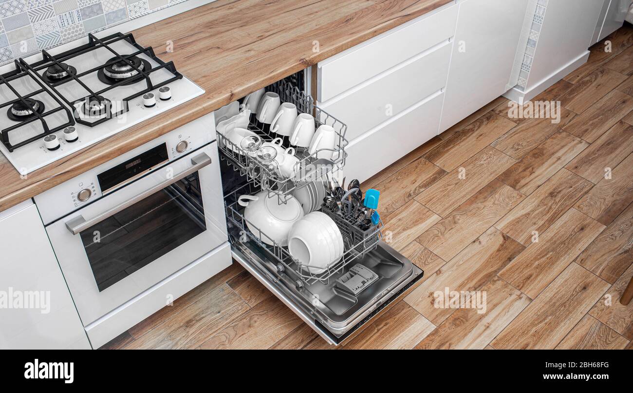 Lavastoviglie a incasso con piatti lavati nella cucina moderna. La lavastoviglie è il miglior aiuto per le donne Foto Stock