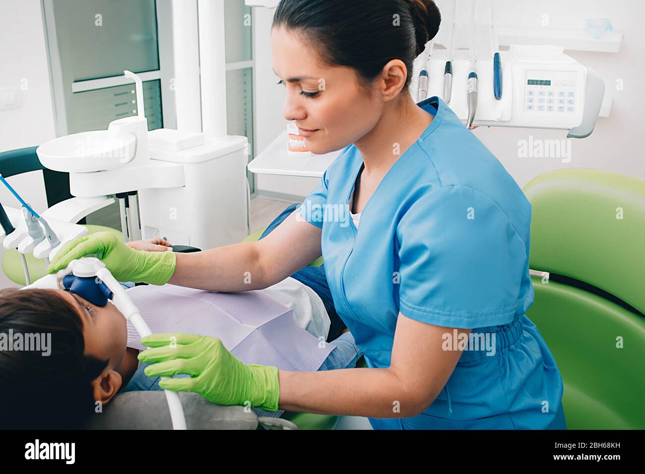 Dentista pediatrico che effettua sedazione inalatoria a un bambino mentre il trattamento dei denti alla clinica dentale. Sedazione Dentistry Foto Stock