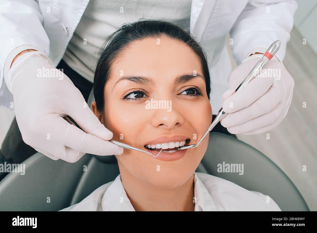 Donna di ottenere denti esame con il suo dentista presso la clinica dentale Foto Stock