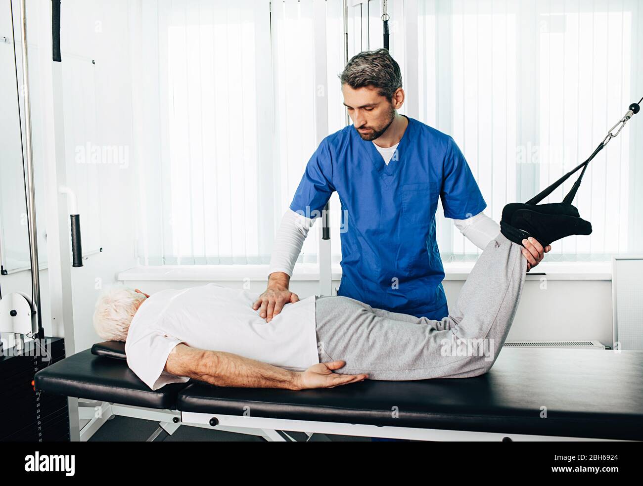 Corpo di recupero del paziente senior durante la cinesiterapia. Trattamento del dolore alle articolazioni, alla colonna vertebrale. Foto Stock